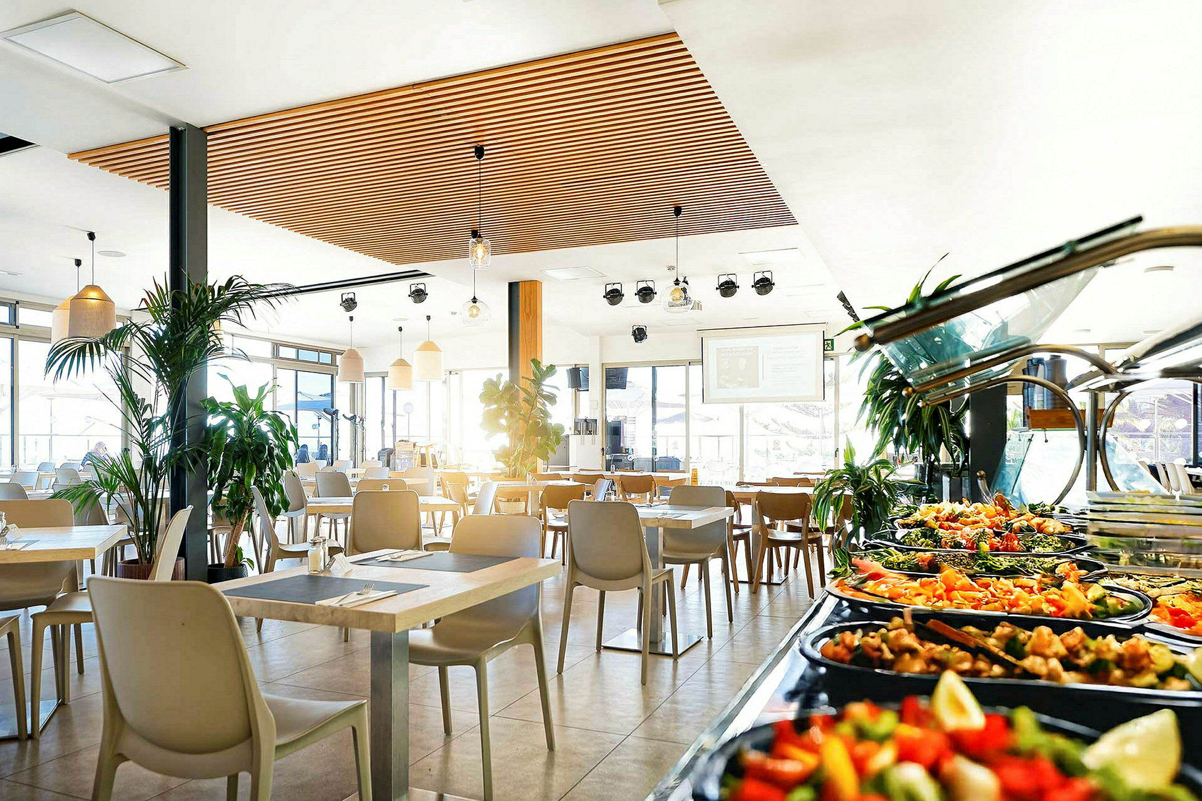 Restaurang med moderna möbler och buffébord med sallader och tillbehör. (AI-genererad text)