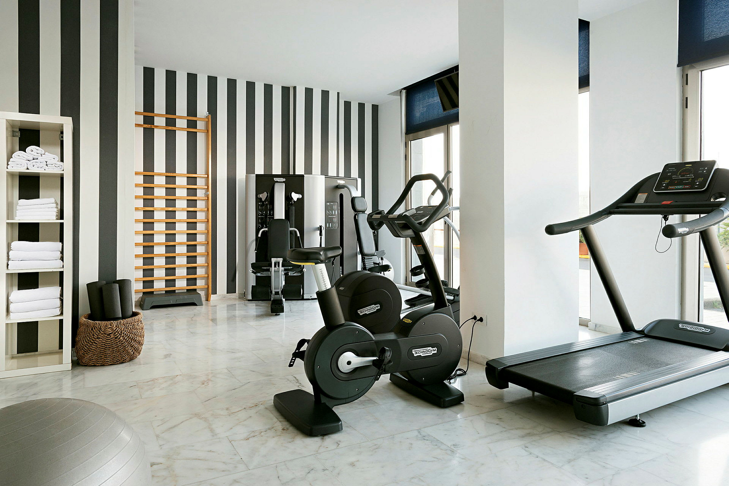 Bild av ett modernt gym med träningsutrustning såsom cykel, löpband och träningsstation. (AI-genererad text)