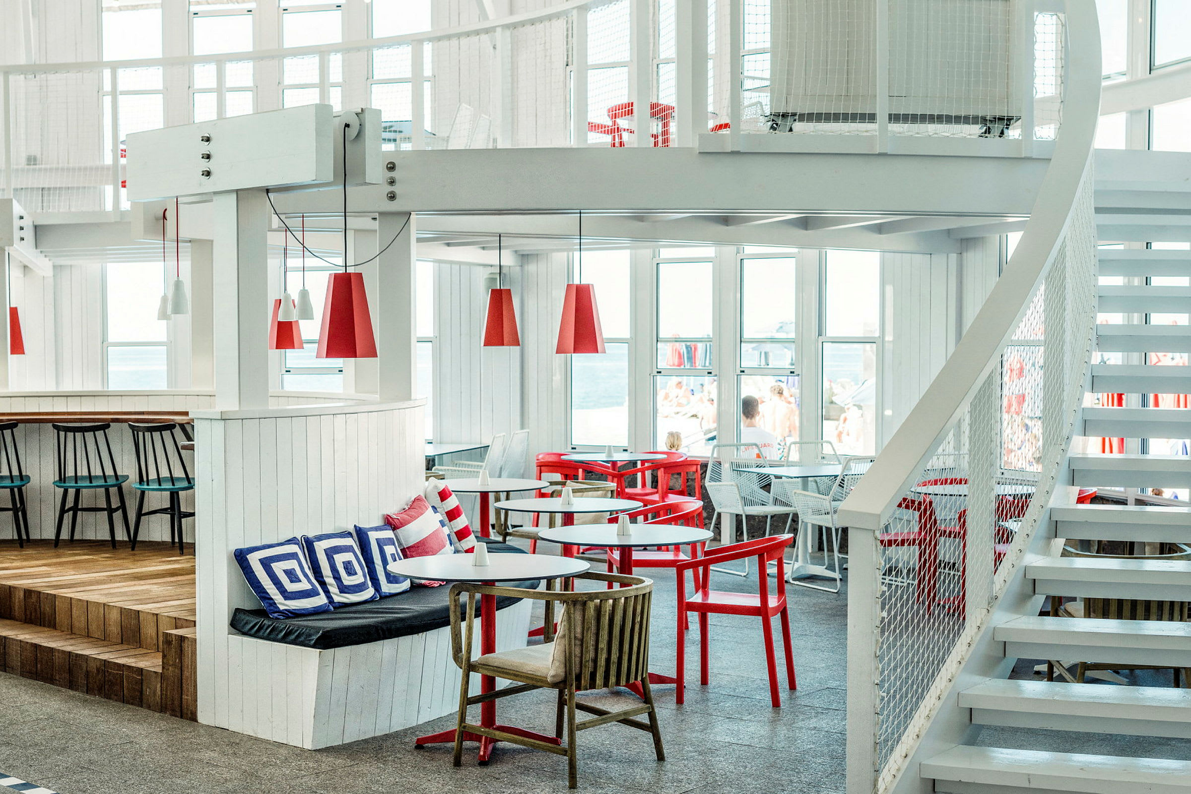 Interiör av en ljus och modern restaurang med röda och vita möbler. (AI-genererad text)