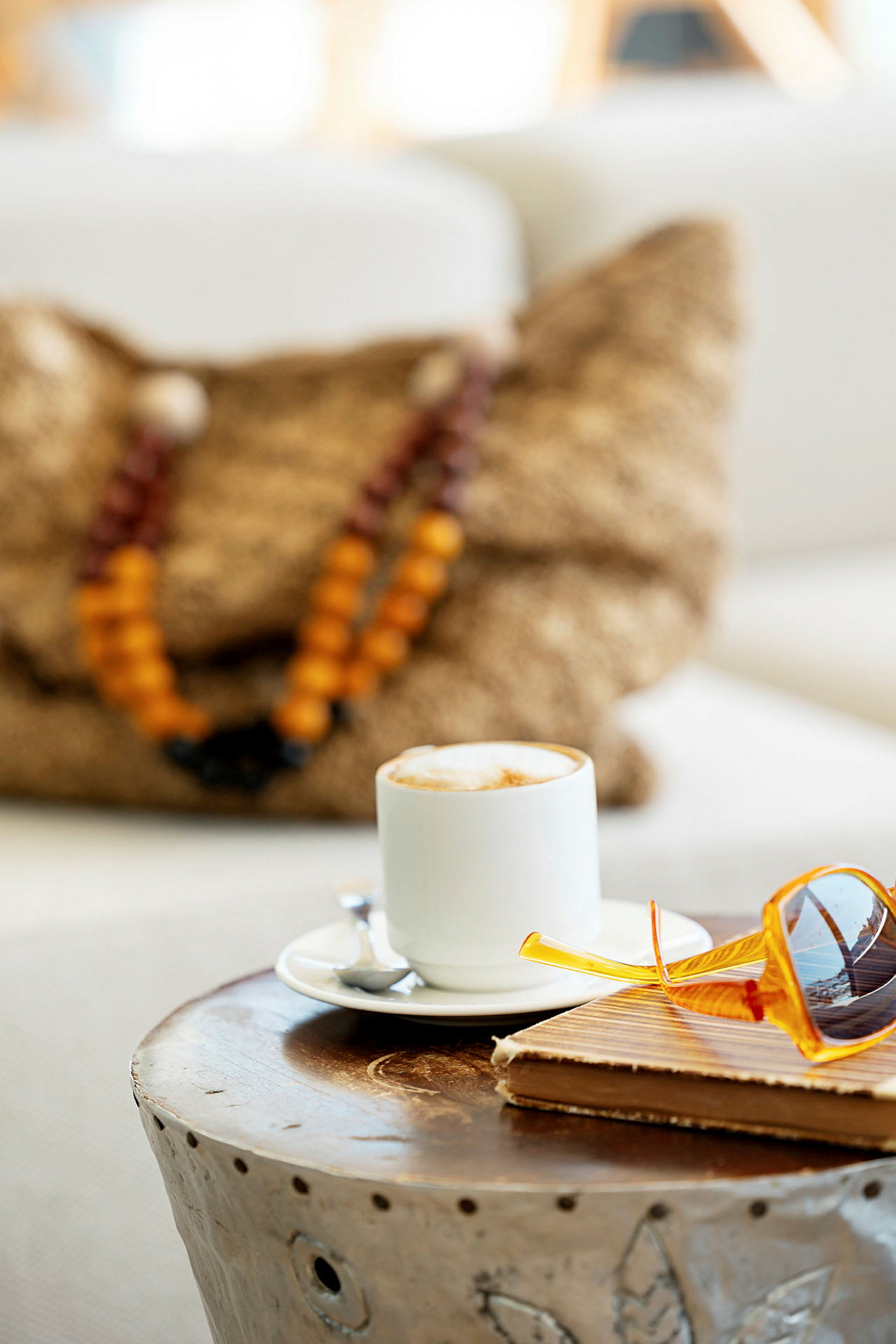En kopp kaffe på ett bord tillsammans med glasögon och en anteckningsbok. (AI-genererad text)