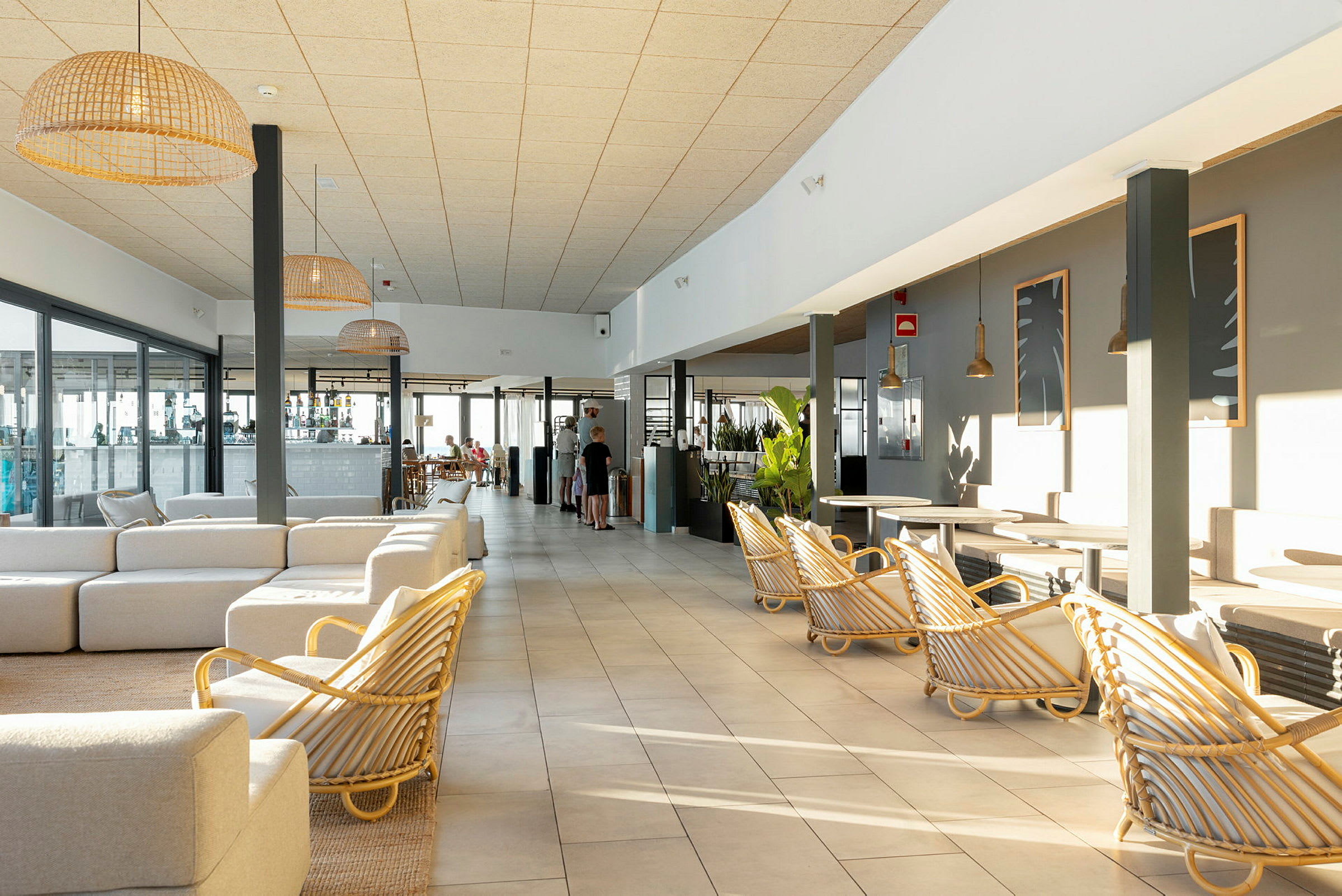 Ett soligt hotellrum med ljusa möbler och stora fönster. (AI-genererad text)