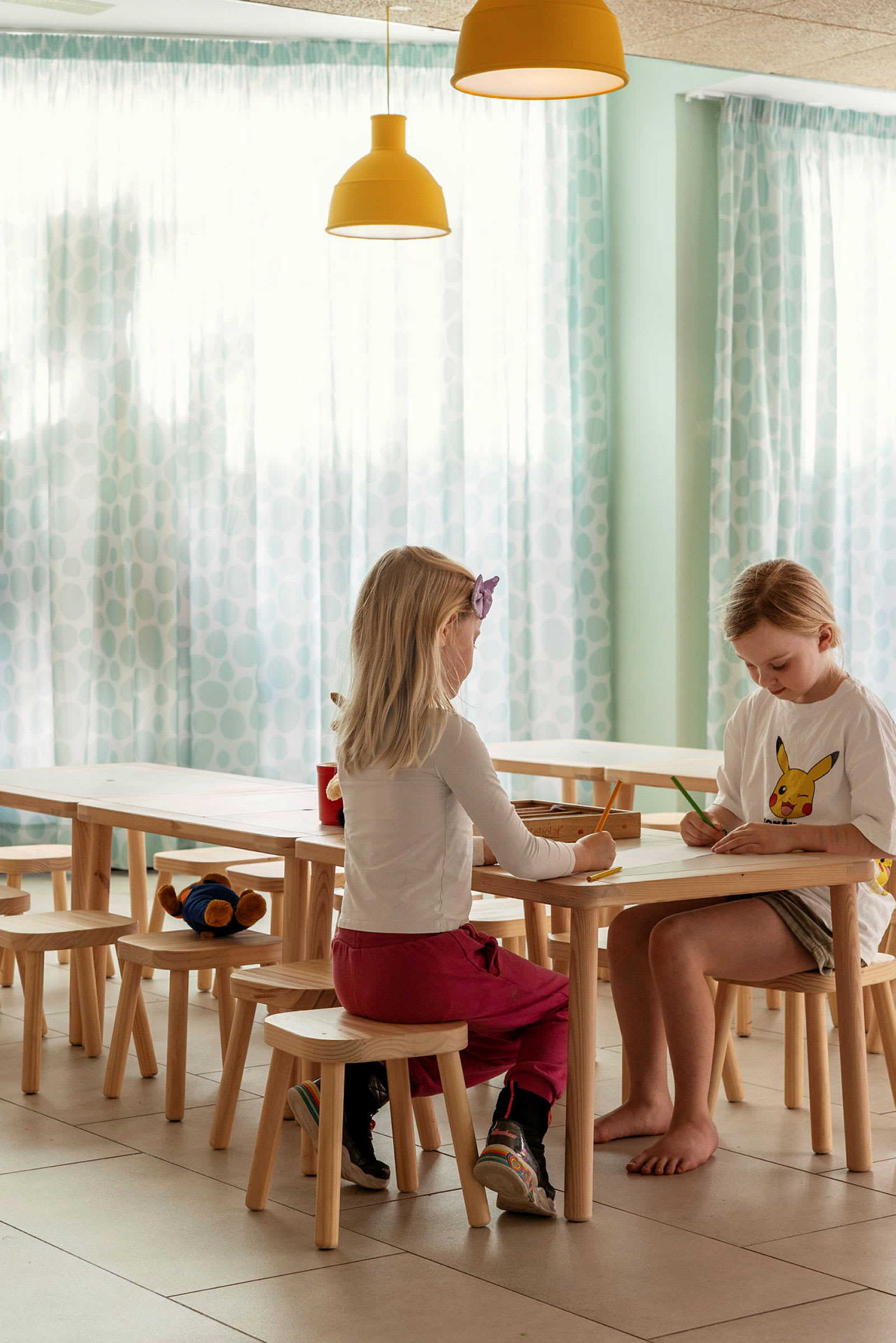 Två barn sitter vid ett bord och ritar. (AI-genererad text)