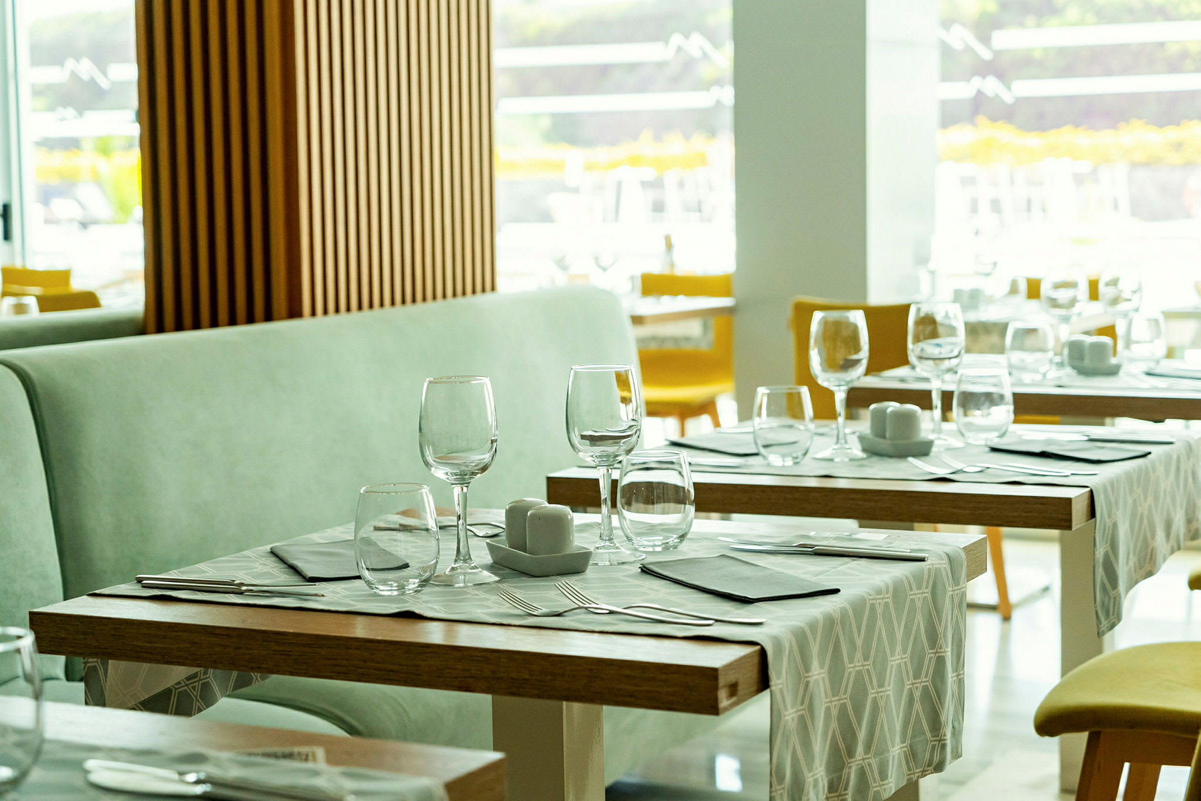 Restaurang med dukade bord, glas och bestick. (AI-genererad text)