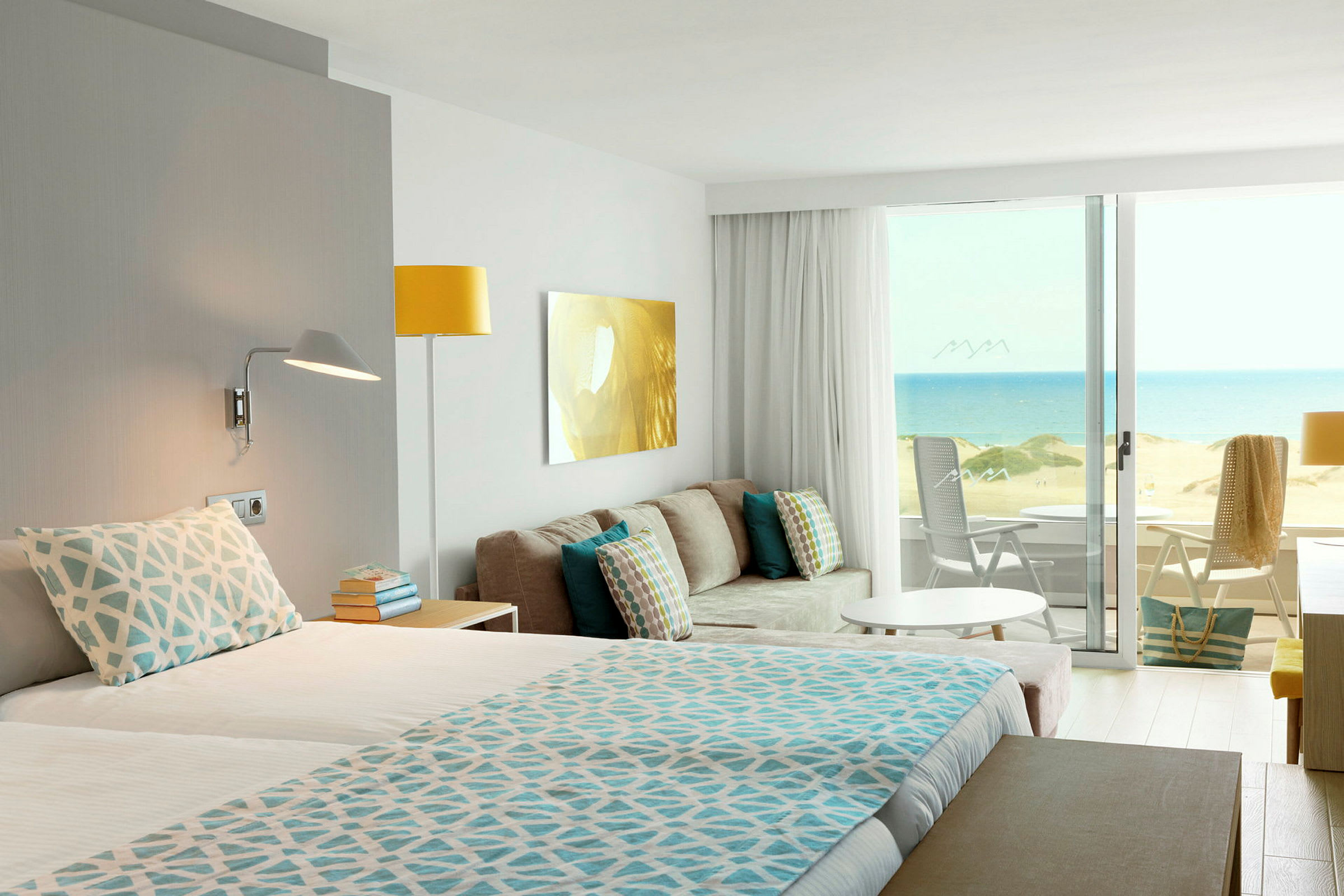 Hotellrum med utsikt över en sandstrand och havet. (AI-genererad text)