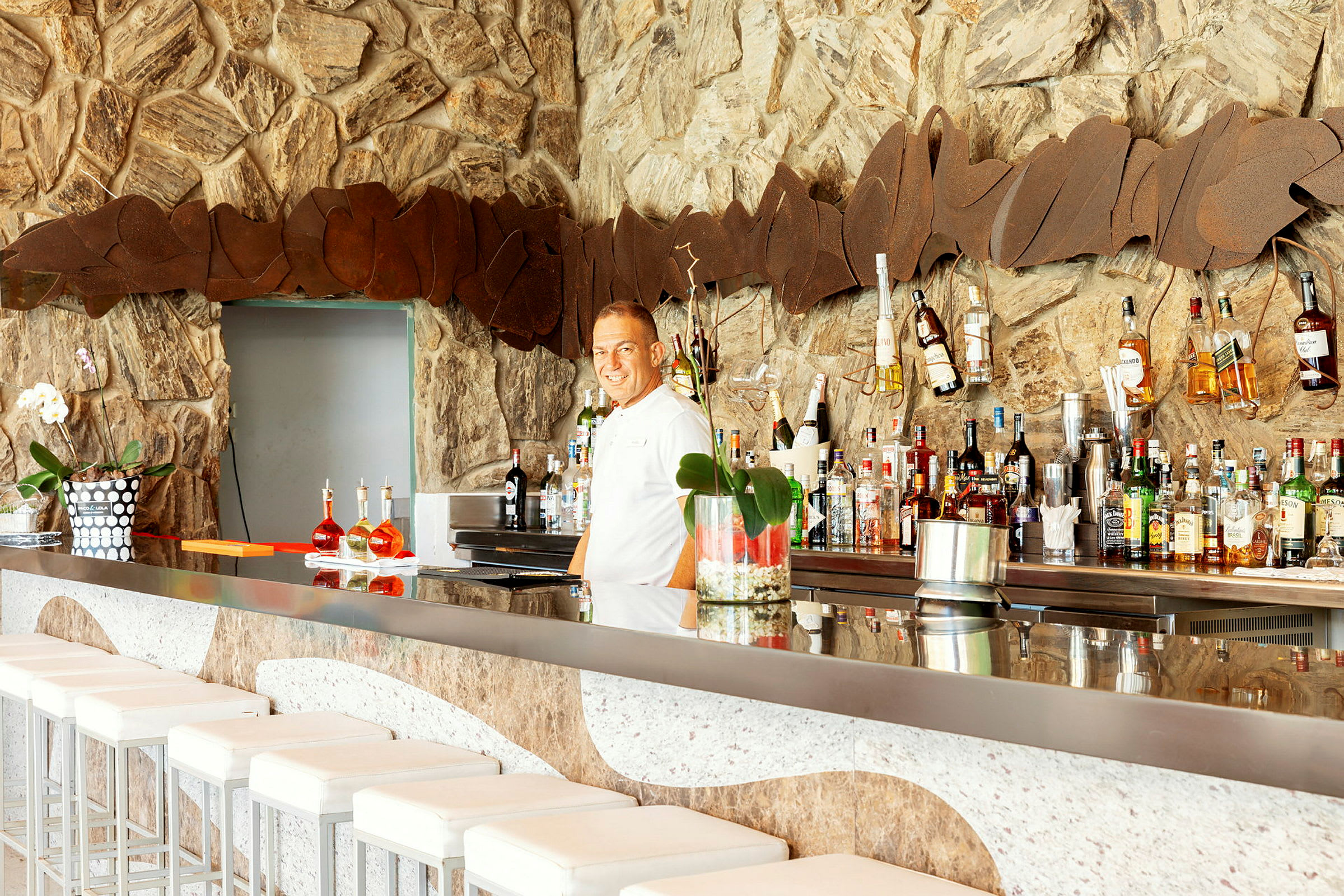 En modern bar med stone detaljer och flaskor på hyllor. (AI-genererad text)