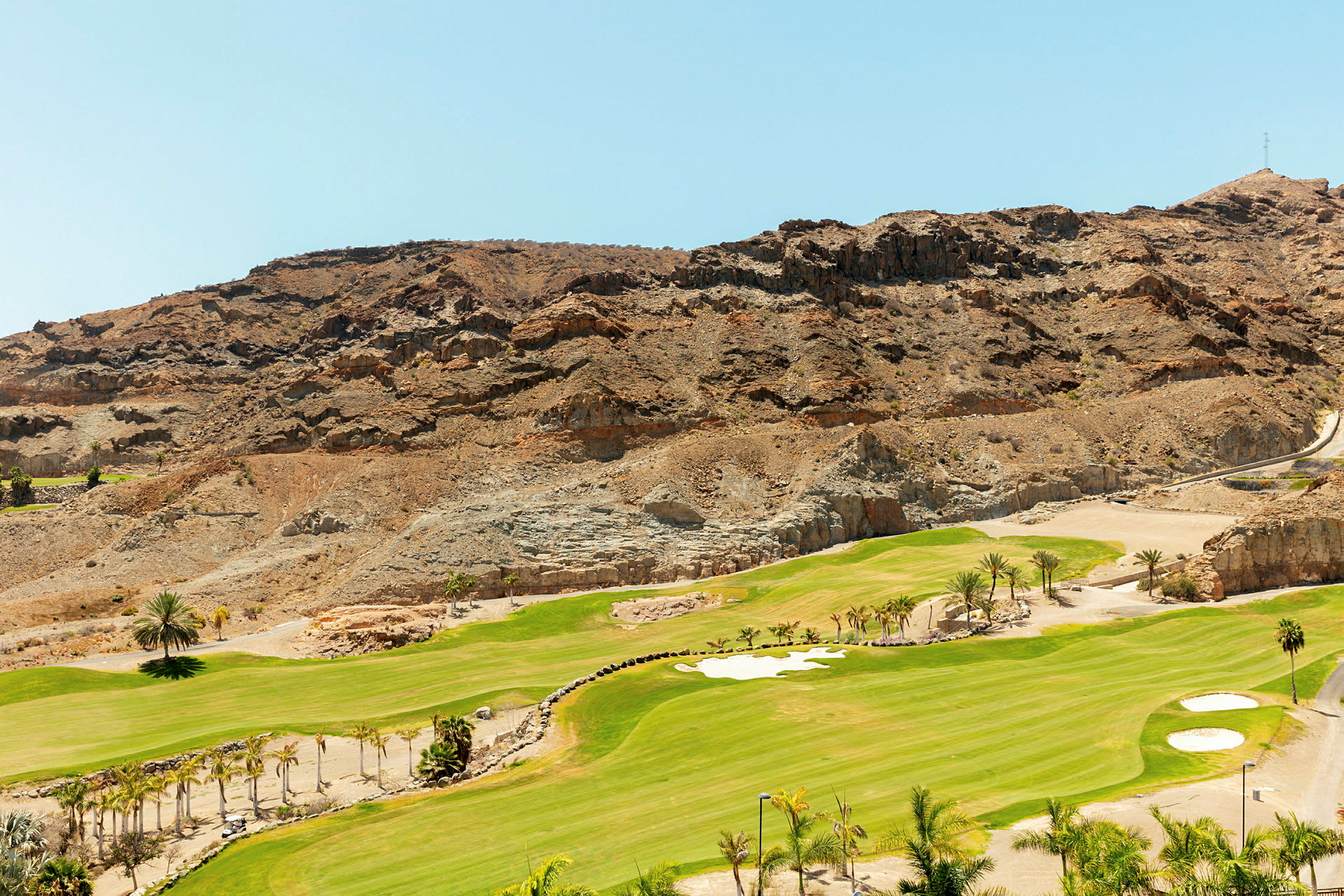 Vy över golfbana med kaktusliknande växter i en ökenlandskap. (AI-genererad text)