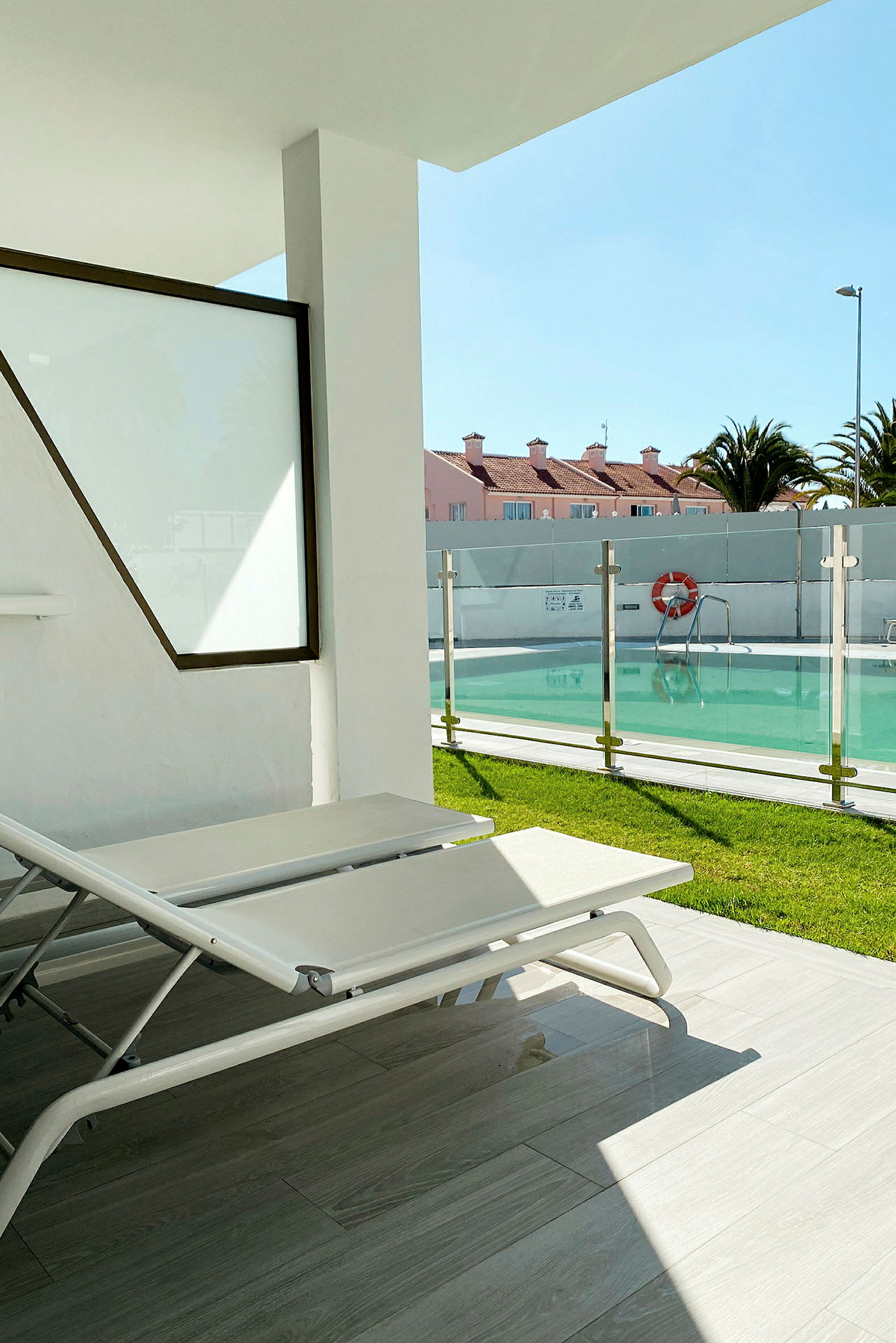 En solstol på en terrass nära en pool. (AI-genererad text)