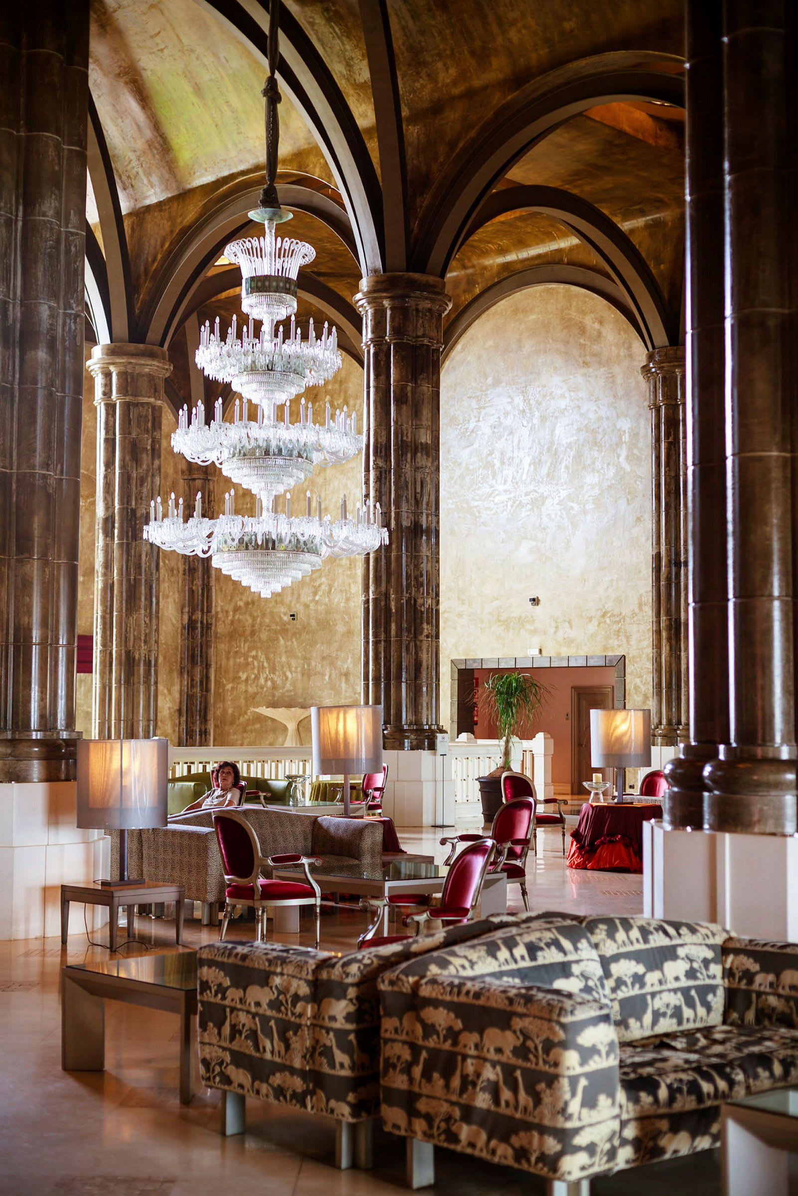 En hotelllobby med lyxiga dekorationer, inklusive en stor kristallkrona och möbler med djurmönster. (AI-genererad text)