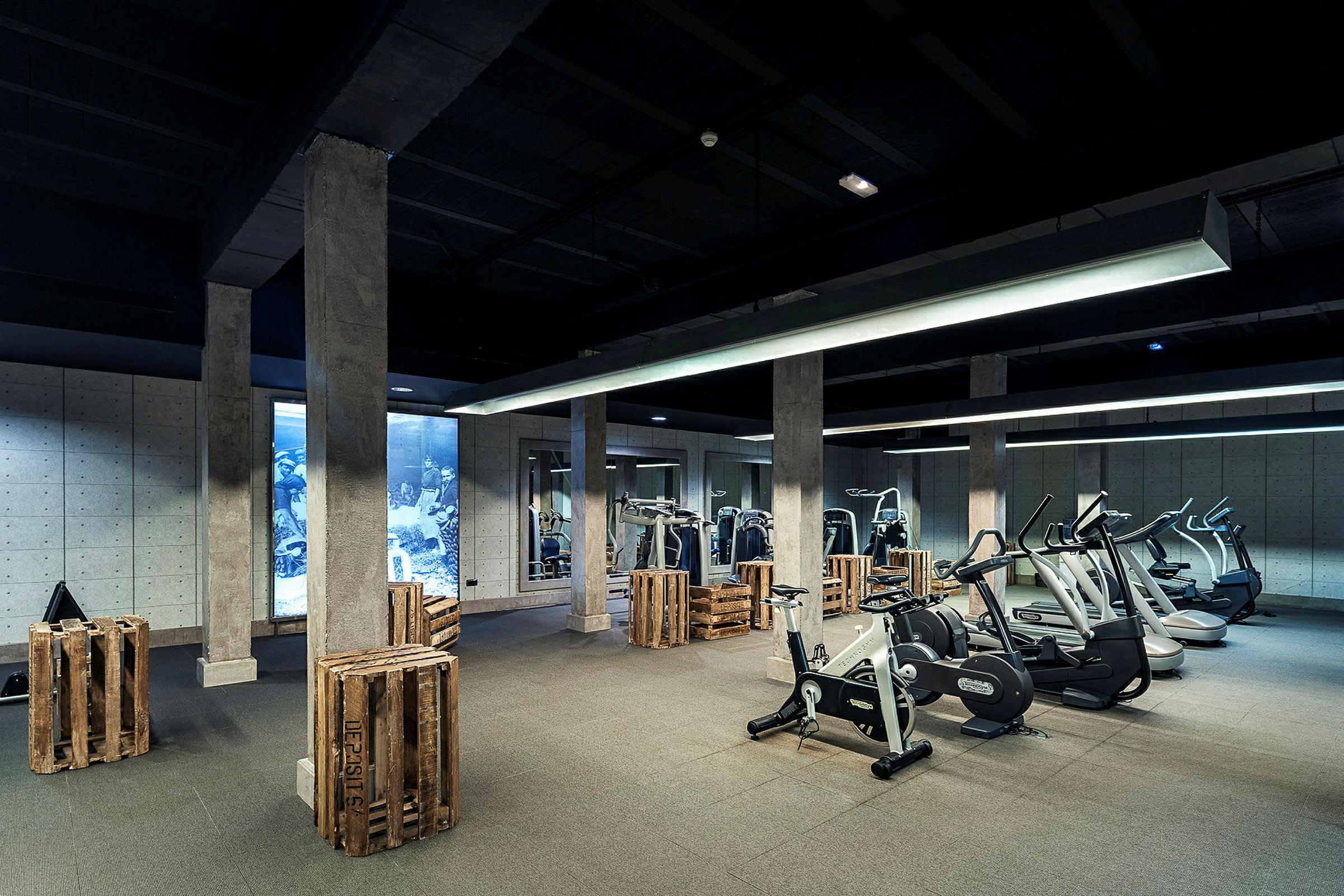 Ett gym med träningsutrustning och träkistor som dekoration. (AI-genererad text)