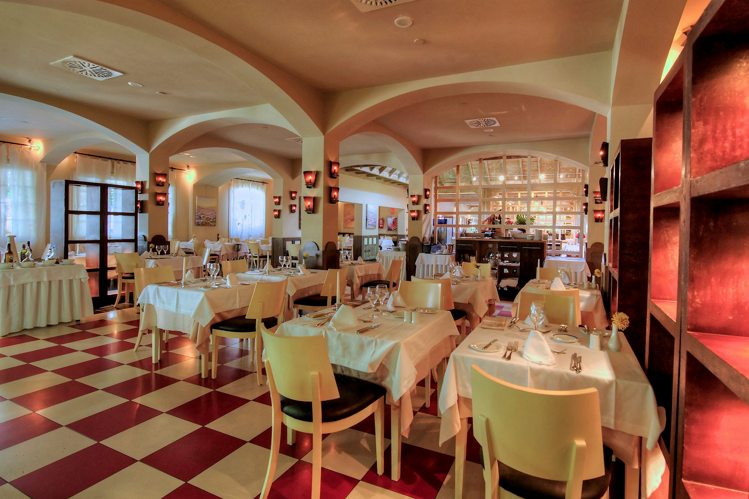 En väl upplyst restaurang med dukade bord och stolar. (AI-genererad text)