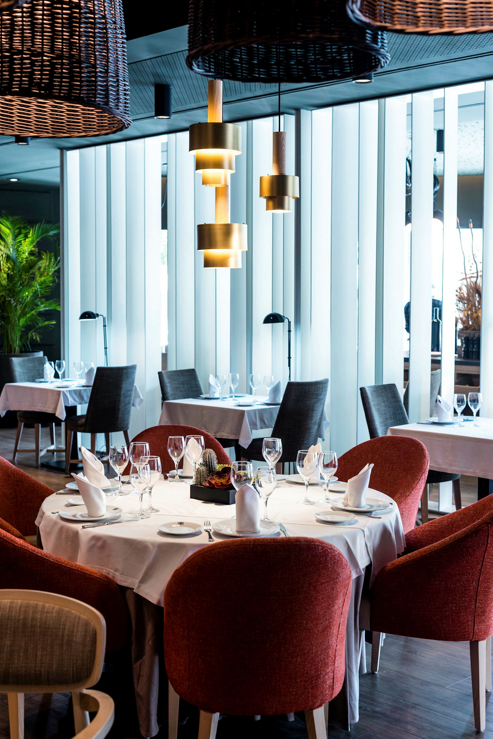 En restaurang med dukade bord och röda stolar. (AI-genererad text)