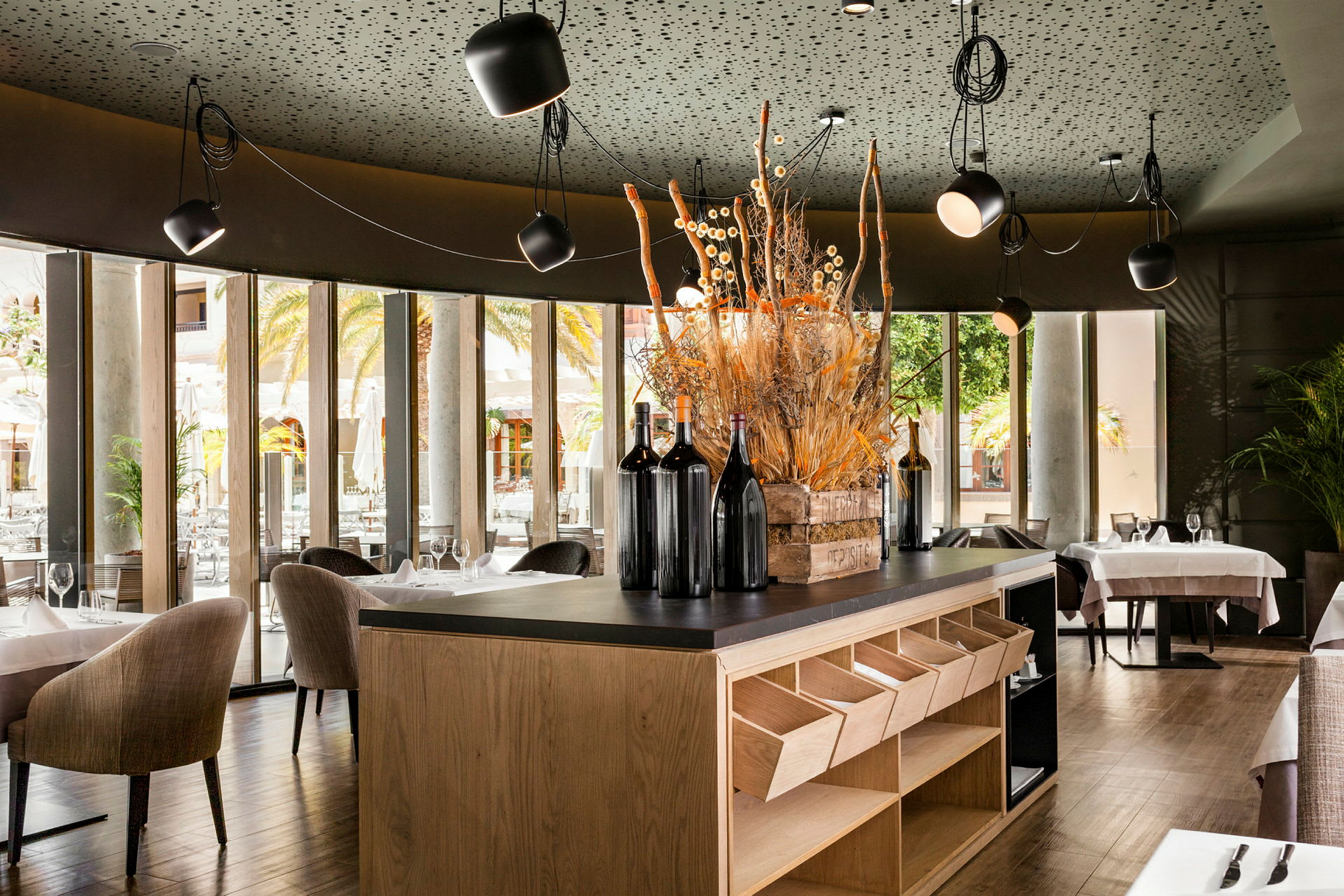 En modern restaurang med stora glasfönster och en dekorerad bar. (AI-genererad text)