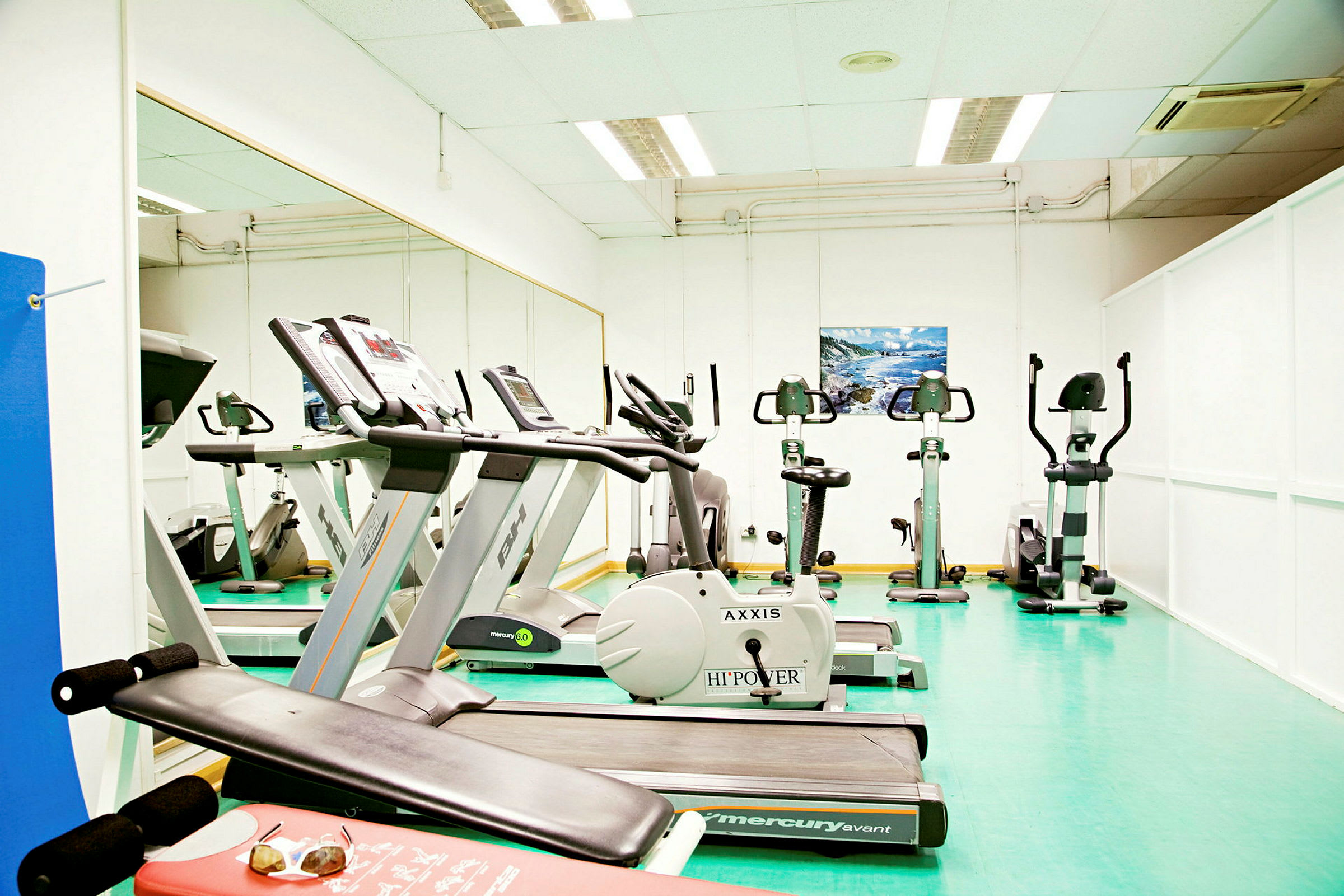 Ett gym med träningsmaskiner, inklusive löpband och motionscyklar. (AI-genererad text)