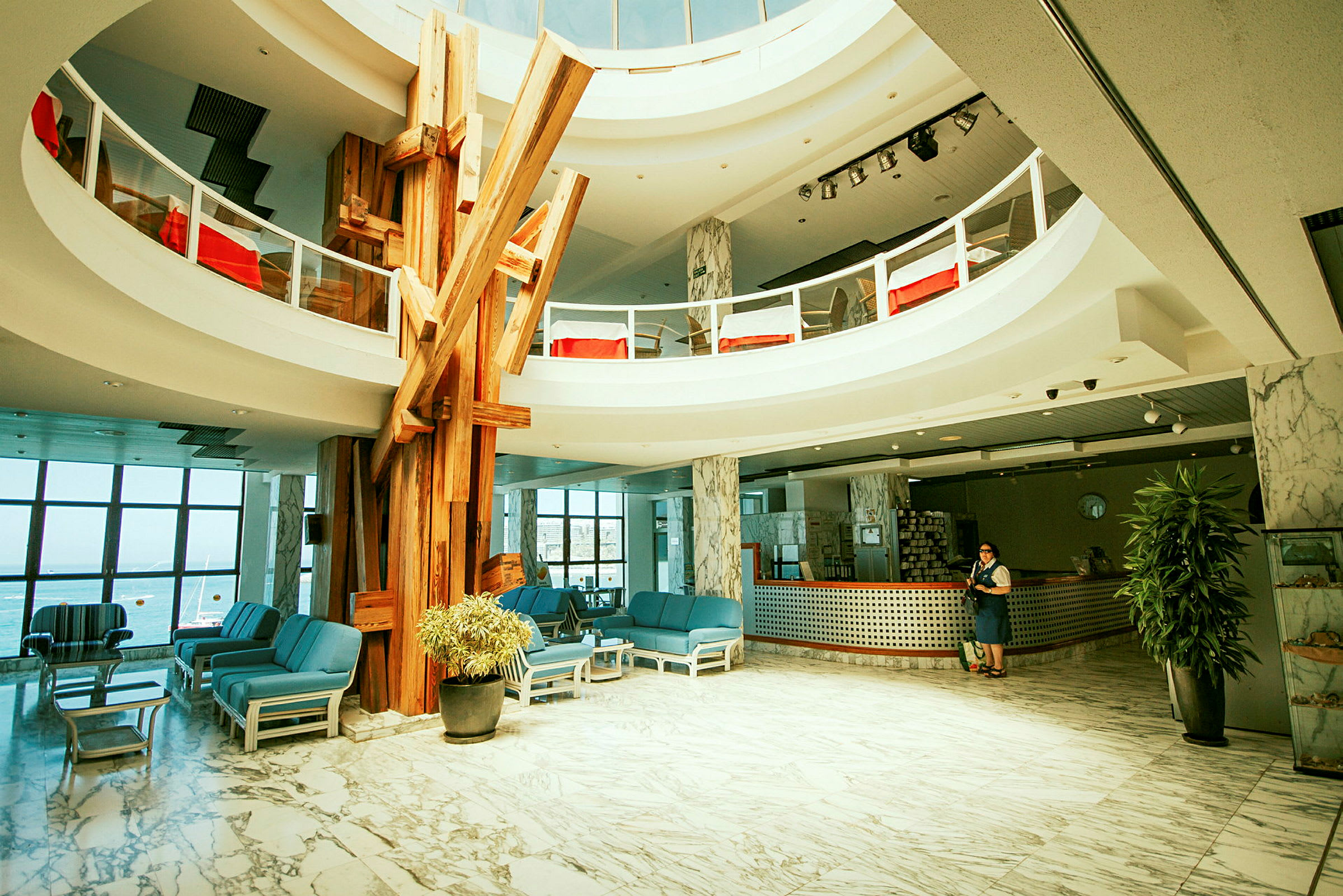 Hotellets lobby med sittgrupper, reception och dekorativa träelement. (AI-genererad text)