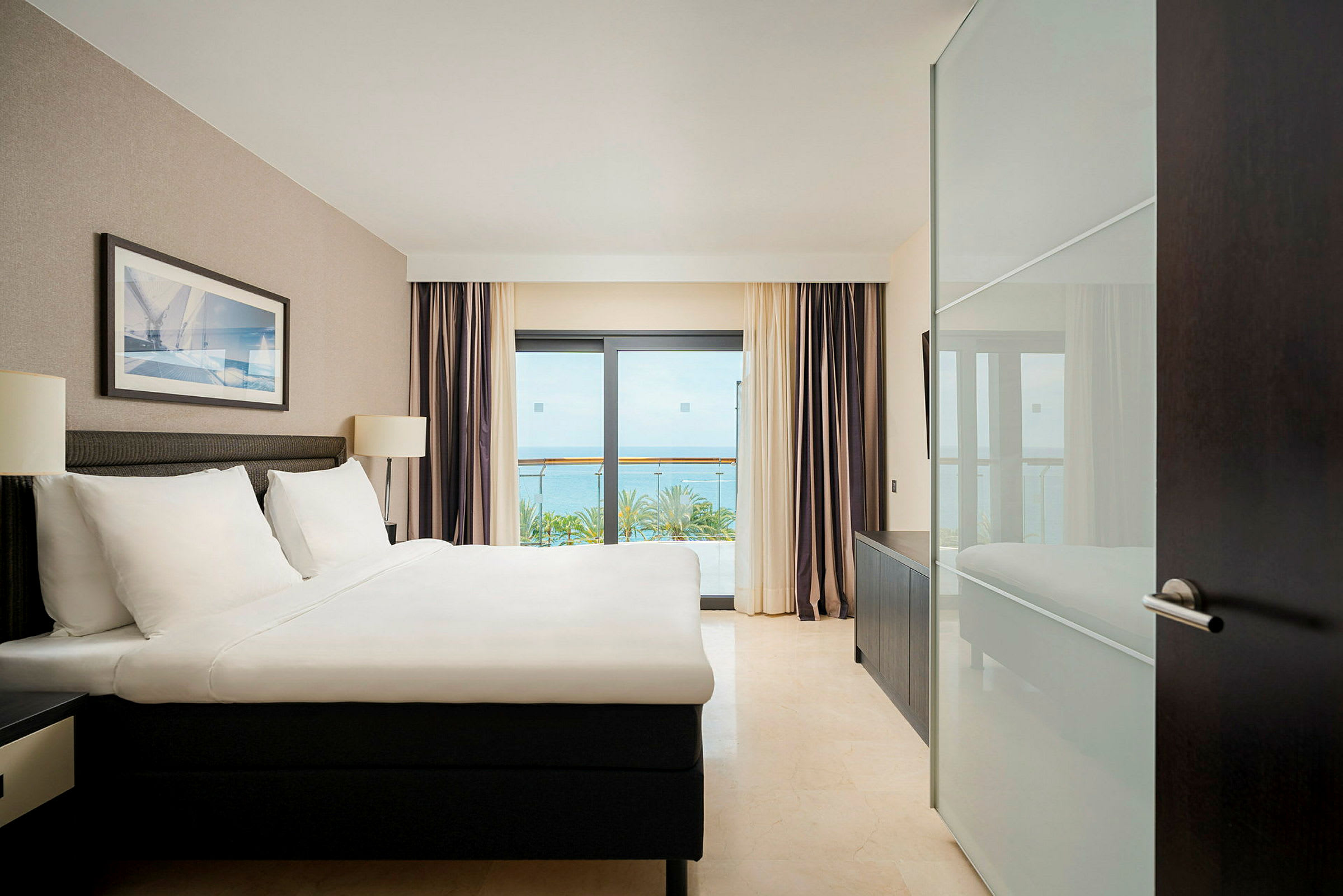 Hotellrum med en dubbelsäng, fönster med havsutsikt. (AI-genererad text)