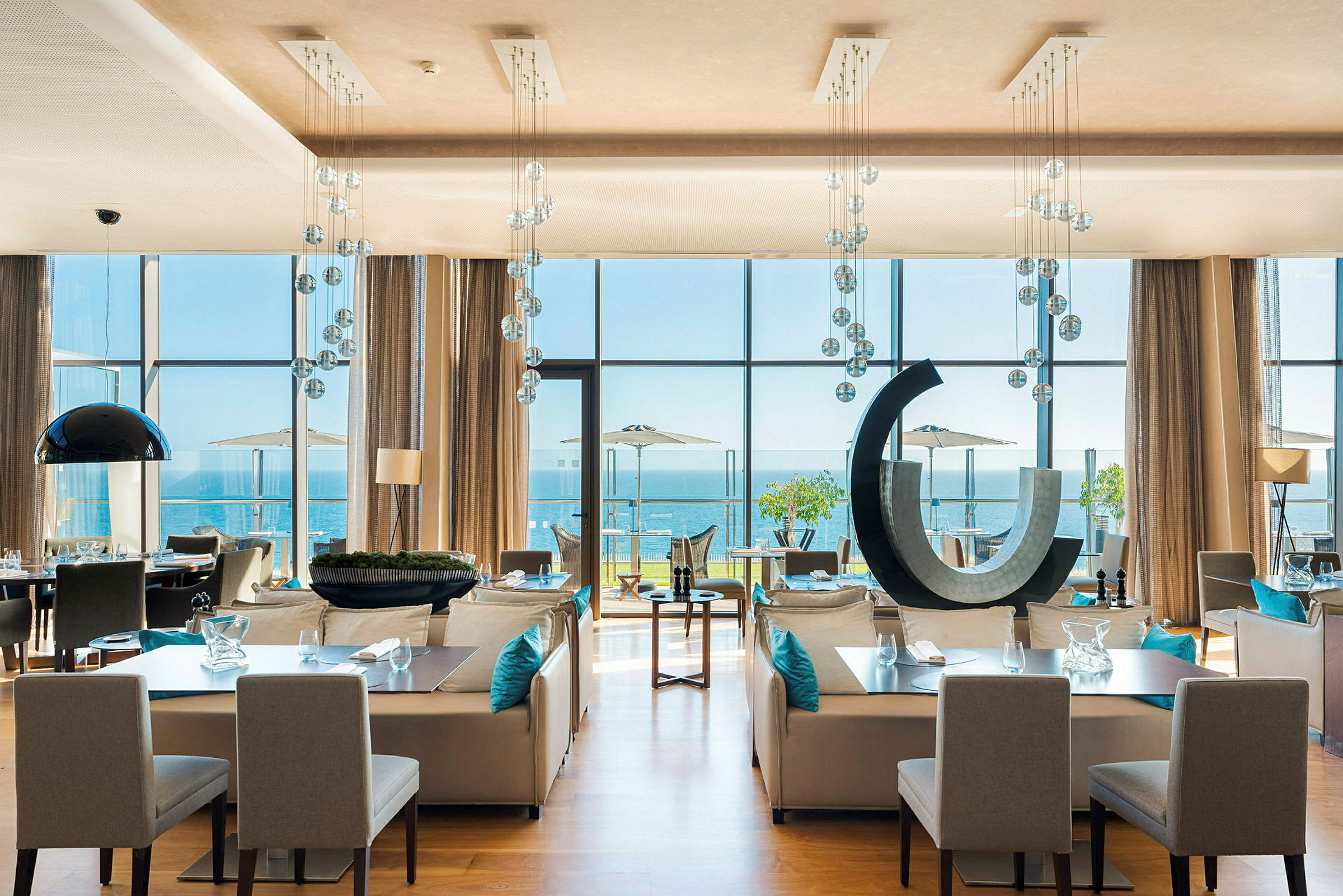 Modern restaurang med stora fönster mot havet. (AI-genererad text)