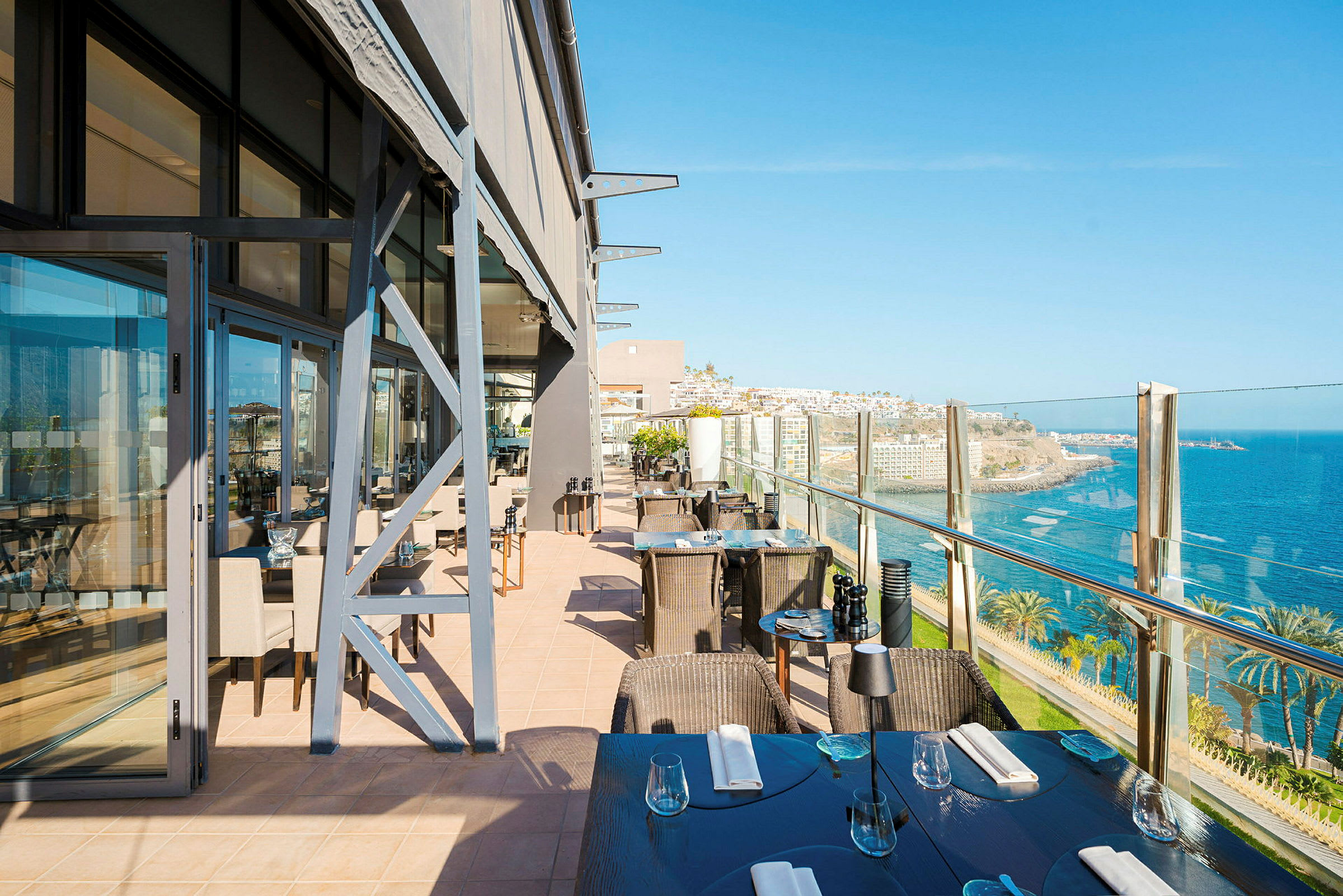 Restaurangterrass med utsikt över havet och kustlandskapet. (AI-genererad text)