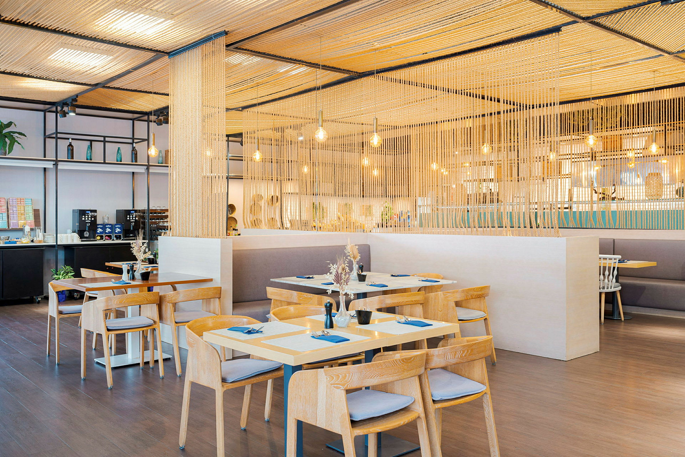 Modern restaurang med träbord och stolar, upplyst med hängande lampor. (AI-genererad text)
