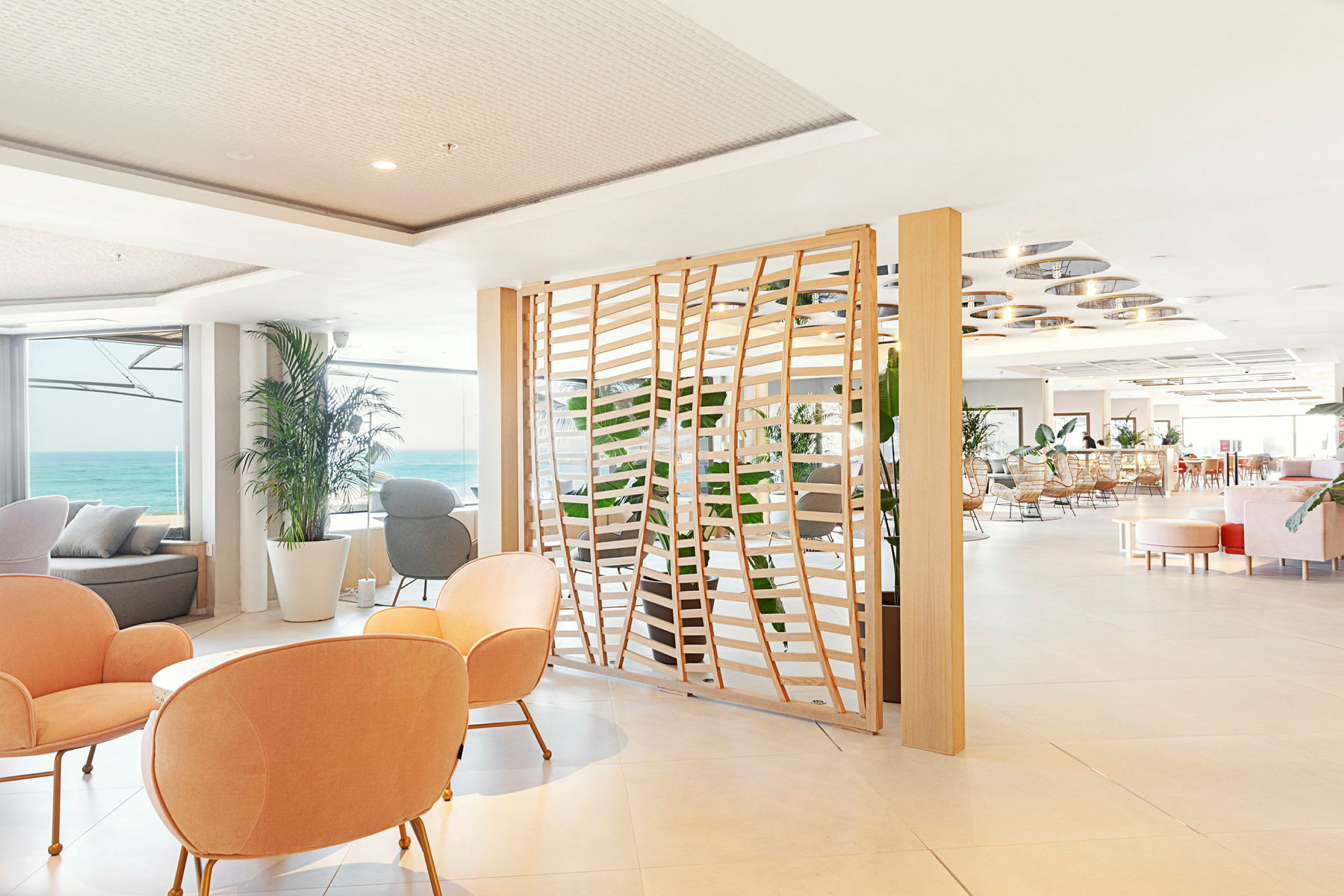 Ljust inredd hotellounge med utsikt över havet. (AI-genererad text)