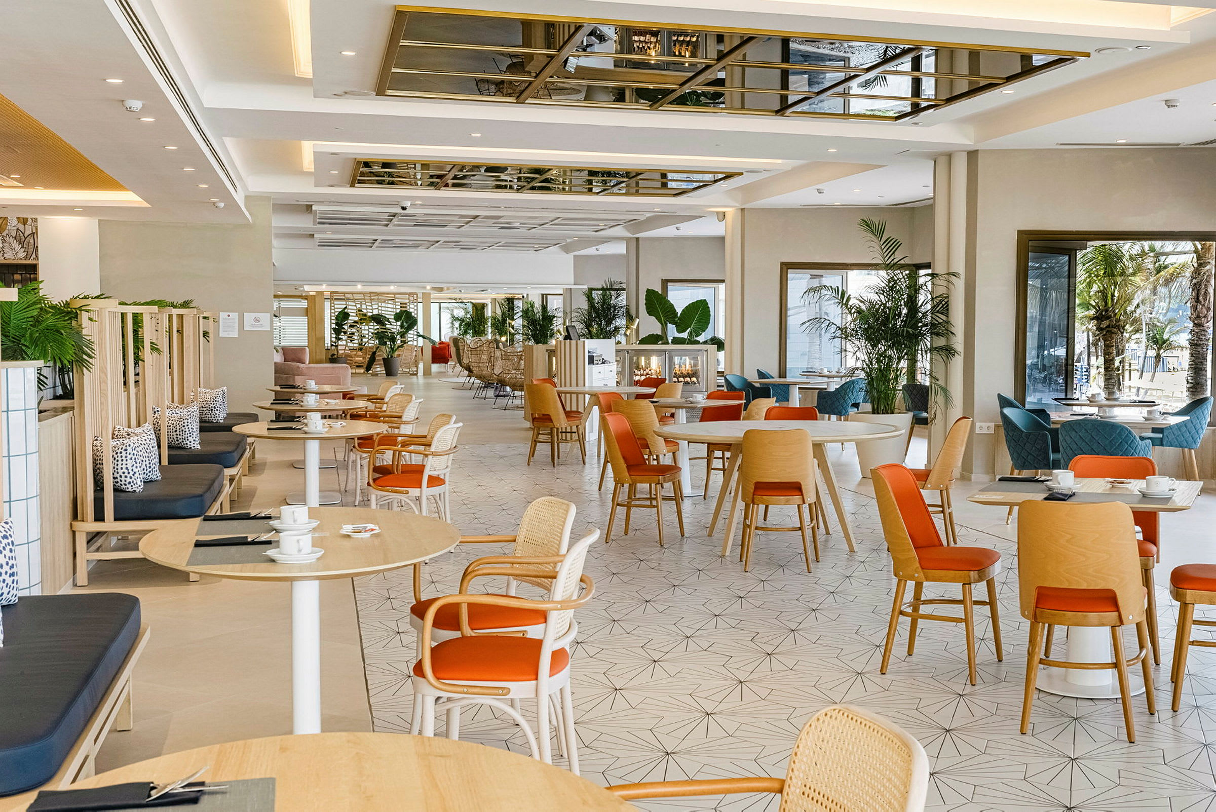 Ett ljust och modernt café med träbord och stolar samt växtdekorationer. (AI-genererad text)