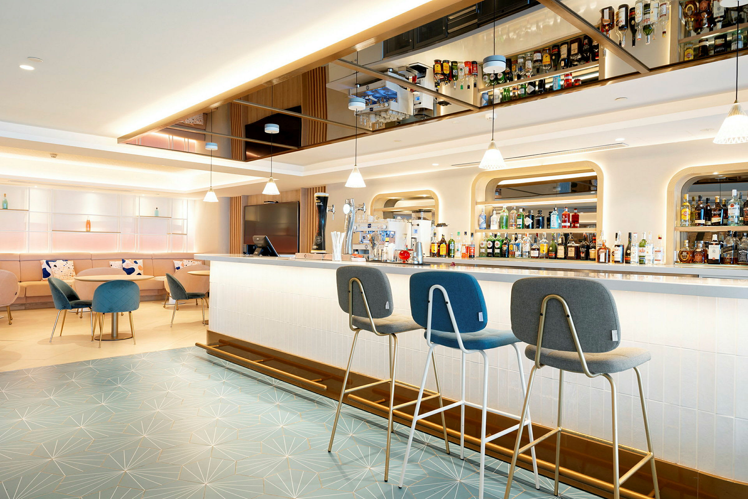 Modern hotellbar med sittplatser och hyllor fyllda med flaskor. (AI-genererad text)