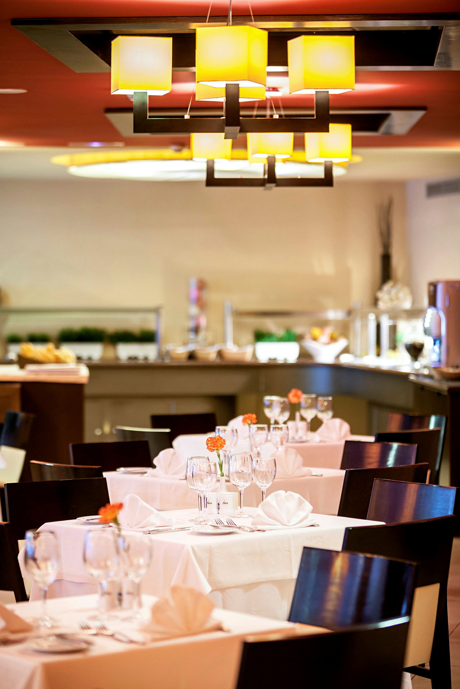 Restaurang med dukade bord, stolar och ljus inredning. (AI-genererad text)