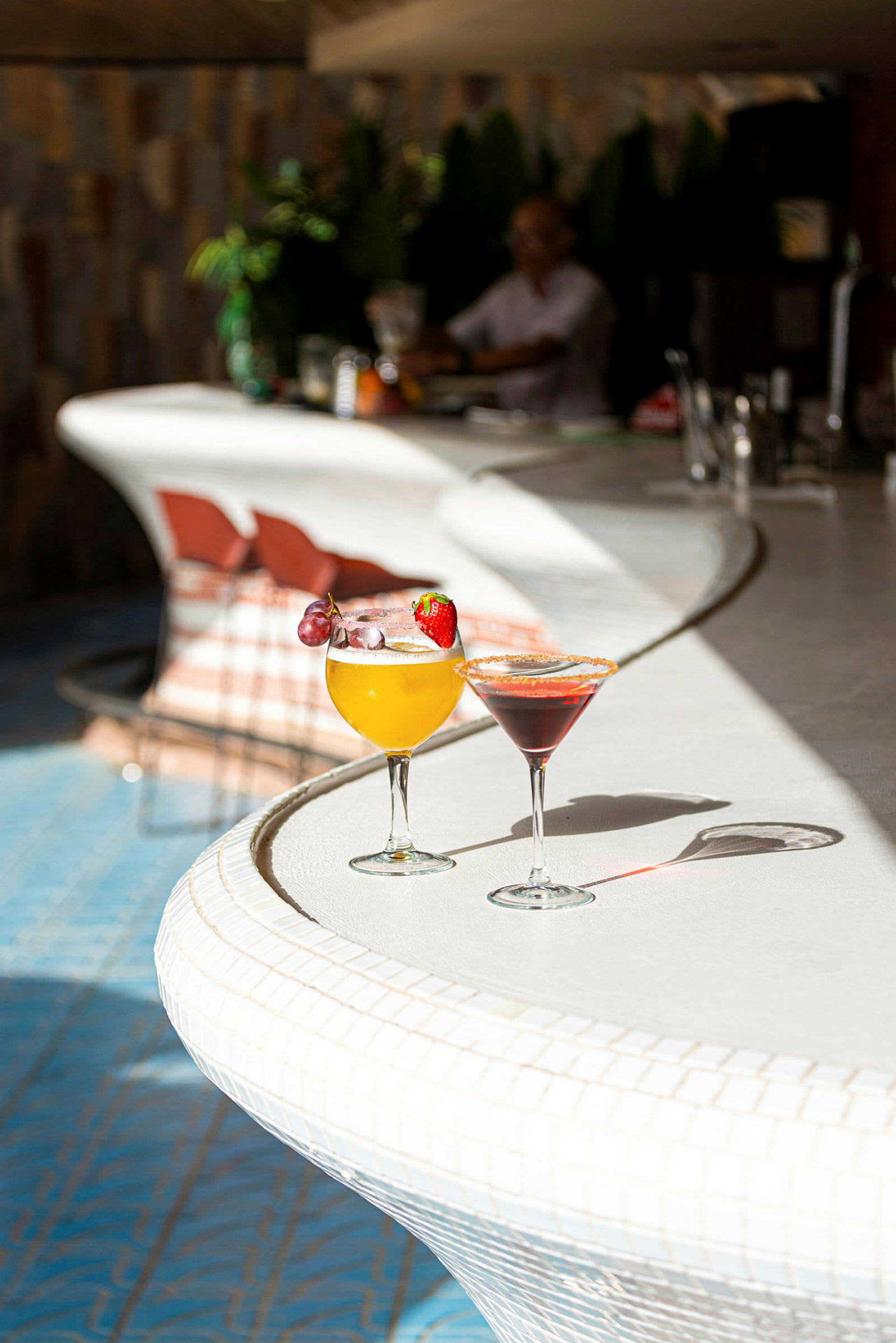 Två cocktails står på en vit bardisk. (AI-genererad text)