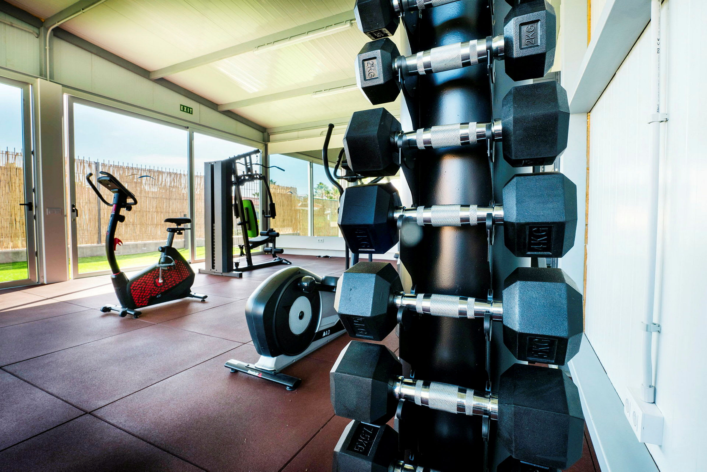 Ett gym med träningsutrustning, inklusive hantlar, motionscykel och maskiner. (AI-genererad text)