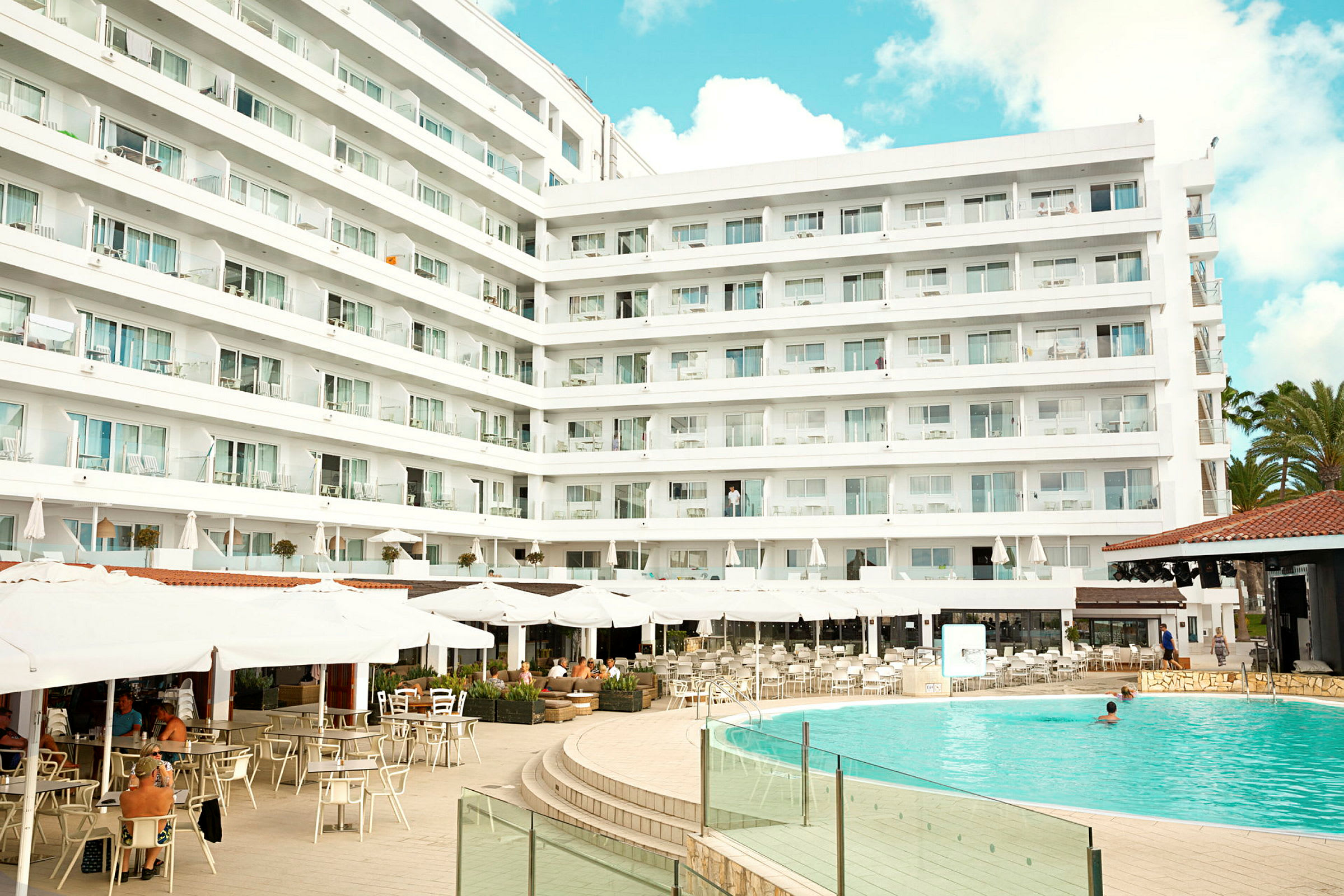 Hotellkomplex med pool och uteservering. (AI-genererad text)