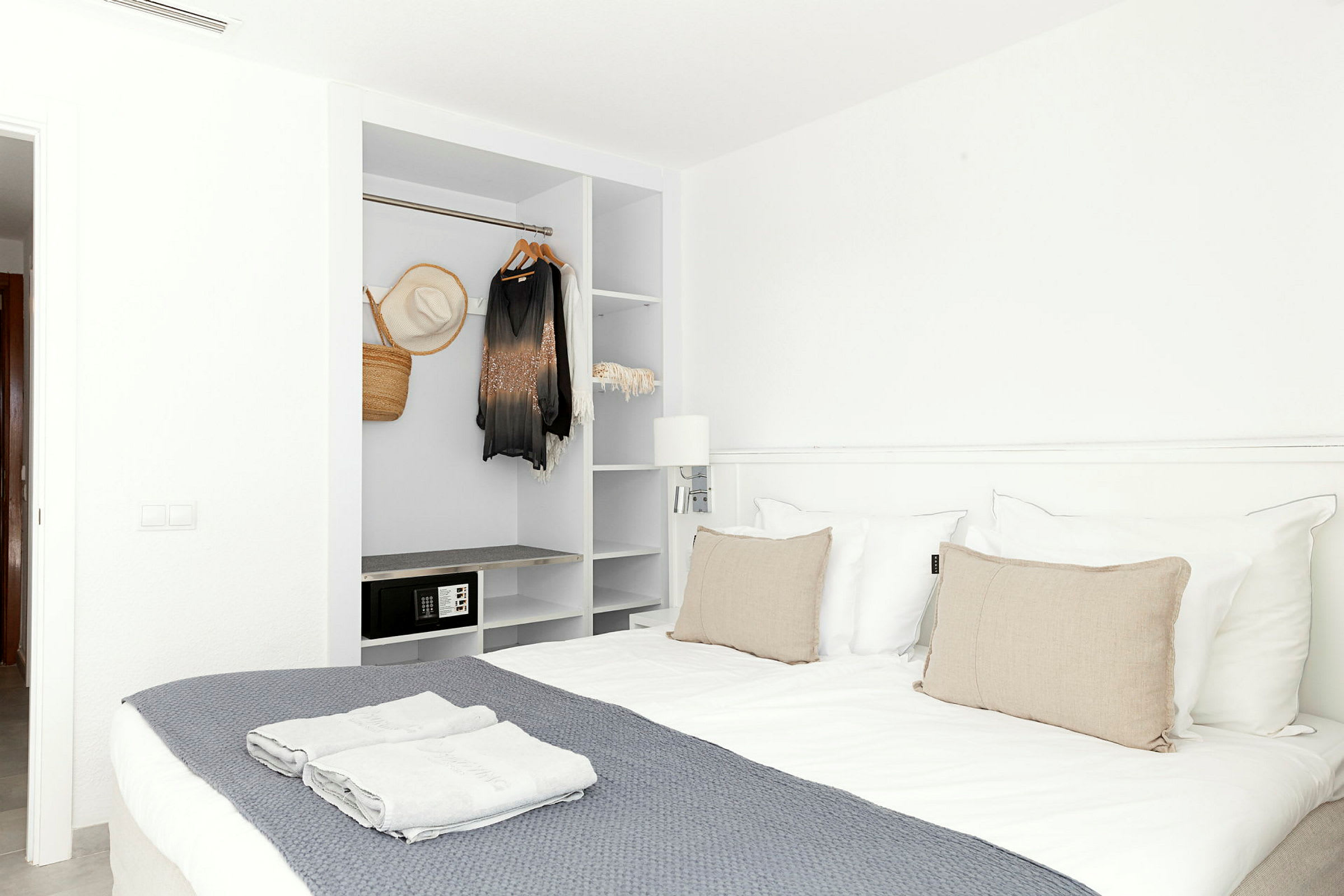 Ett hotellrum med en dubbelbädd och en öppen garderob. (AI-genererad text)
