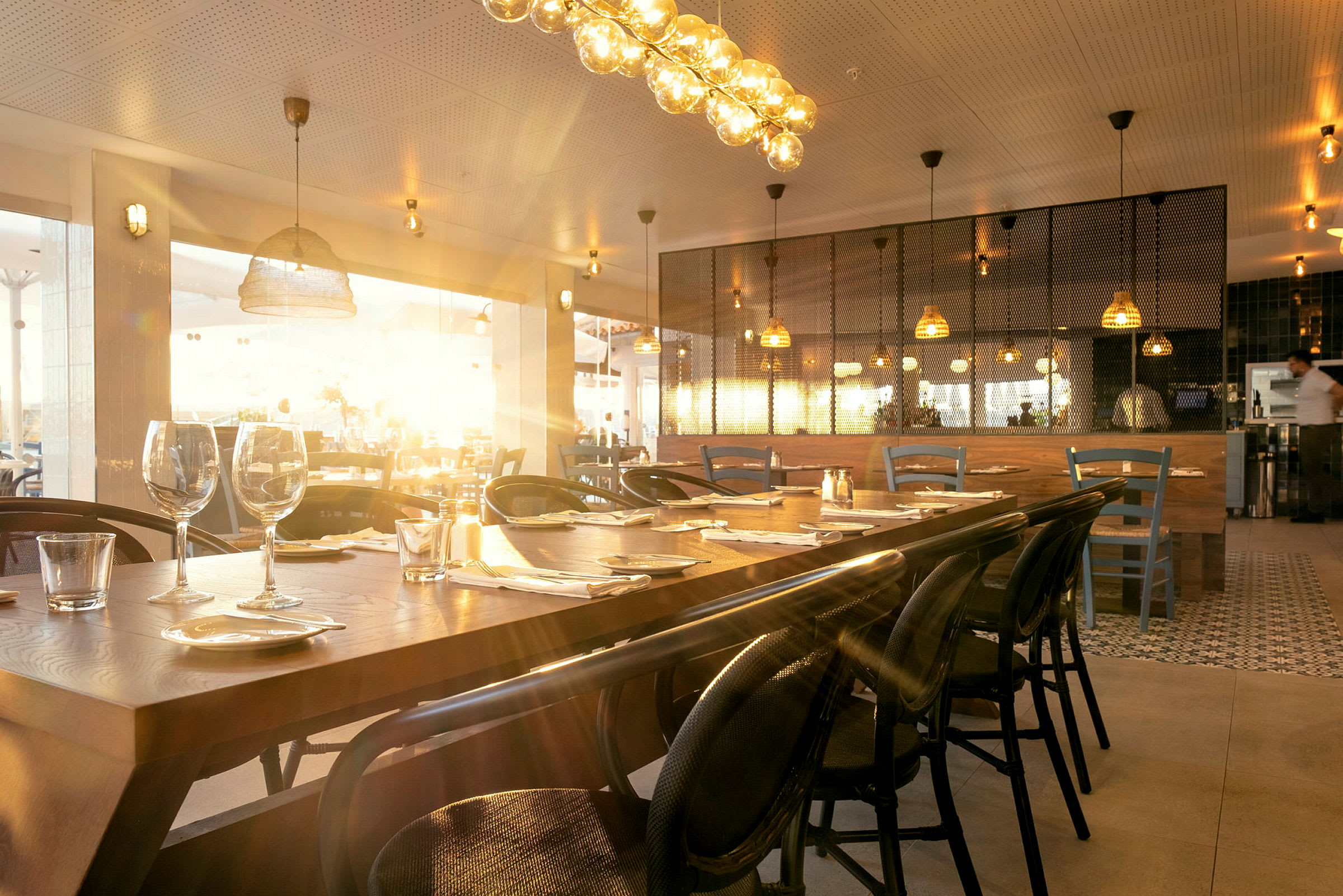 En stämningsfull restaurang med bord dukade för gäster och varm belysning. (AI-genererad text)
