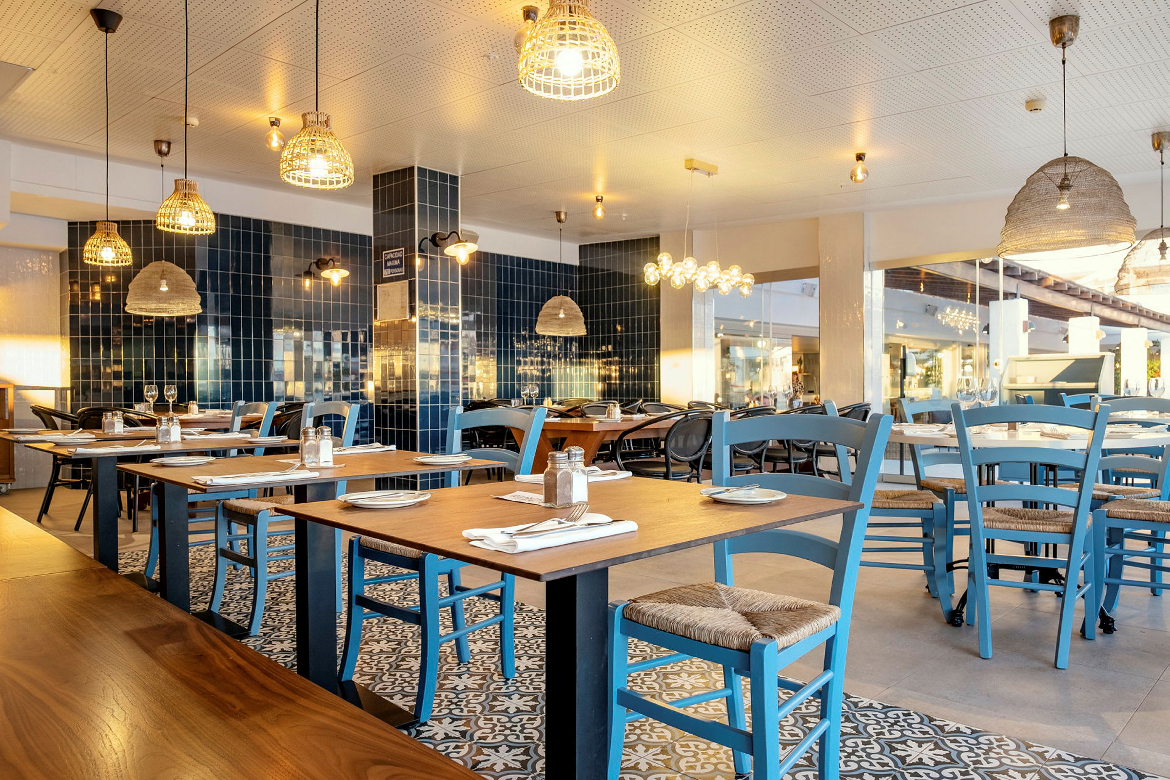 En restaurang med bord och blå stolar. (AI-genererad text)