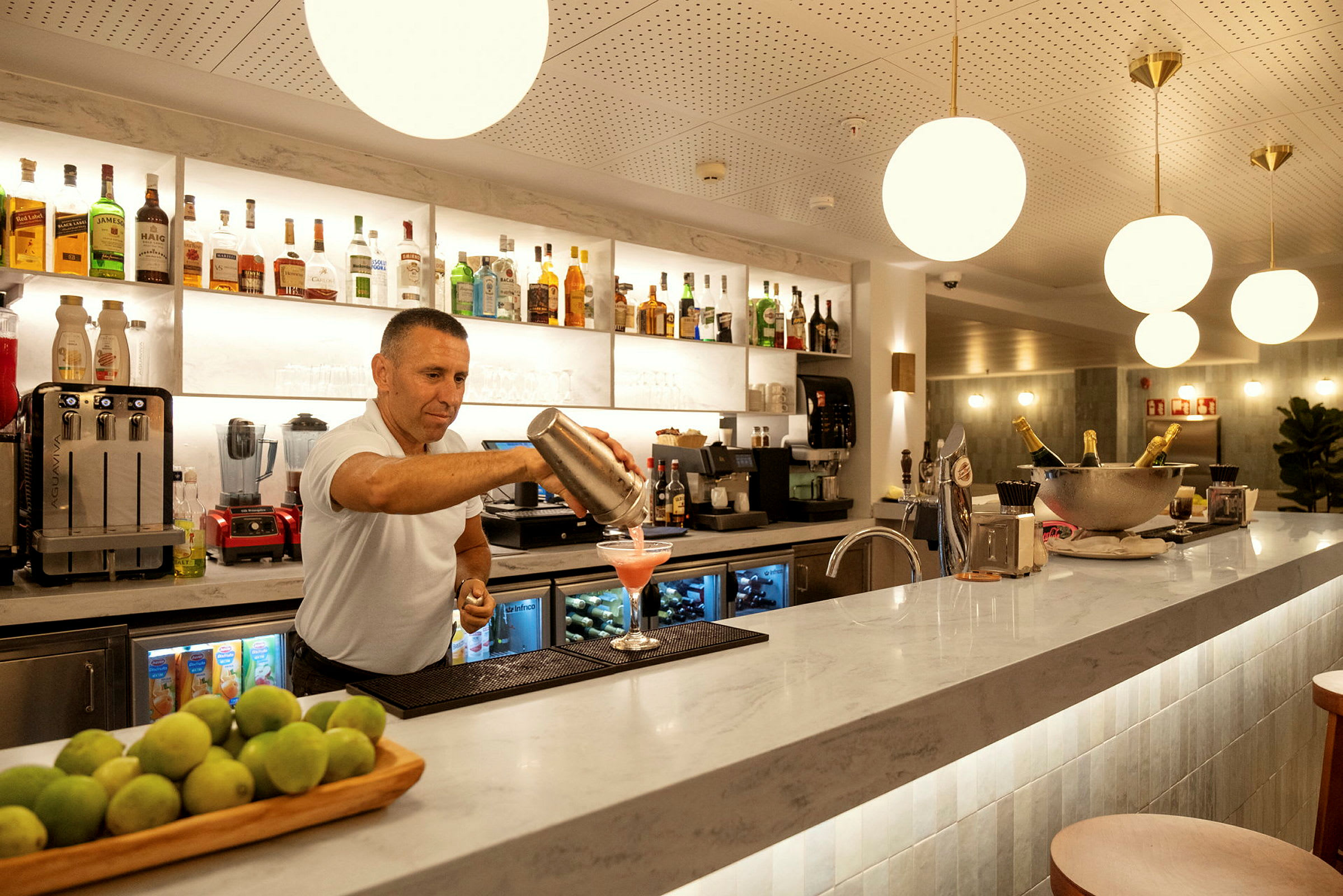 Barområde med en kock som häller upp en cocktail. (AI-genererad text)