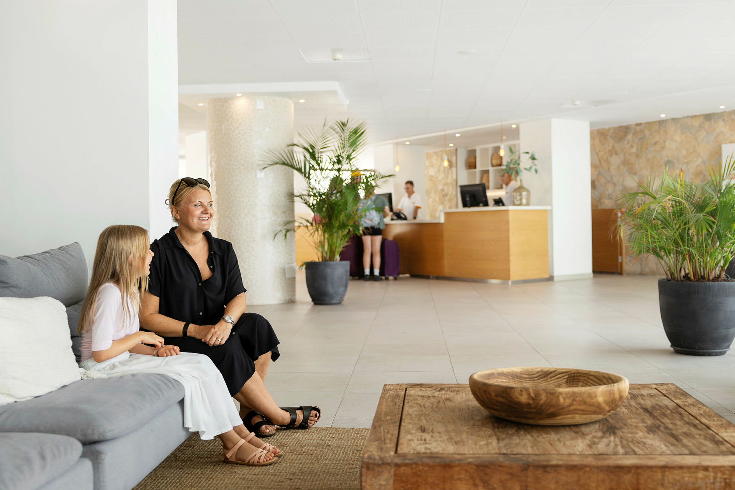 Hotelllobby med soffor, bord och reception. (AI-genererad text)