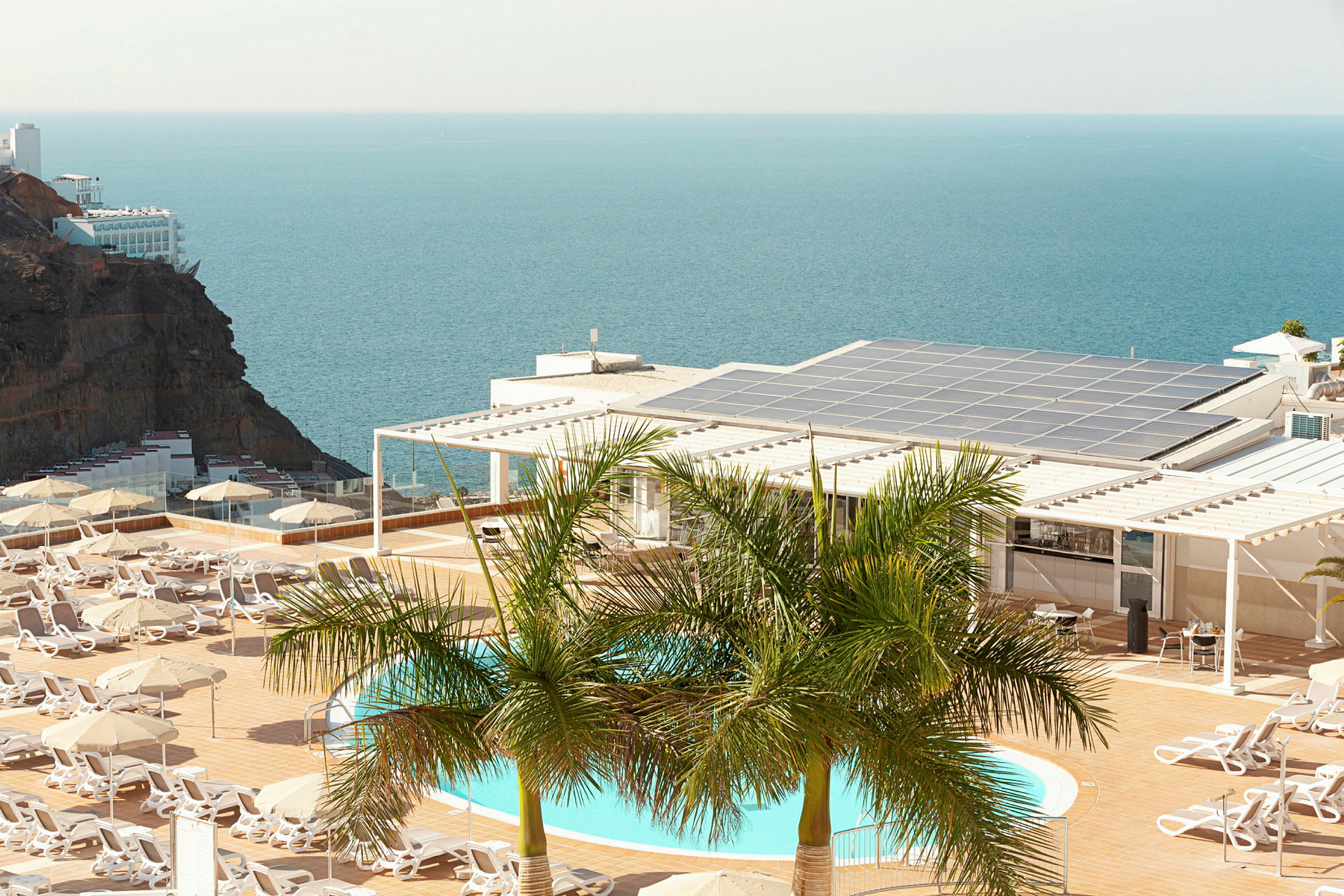 En pool och solstolar på en terrass med utsikt över havet. (AI-genererad text)