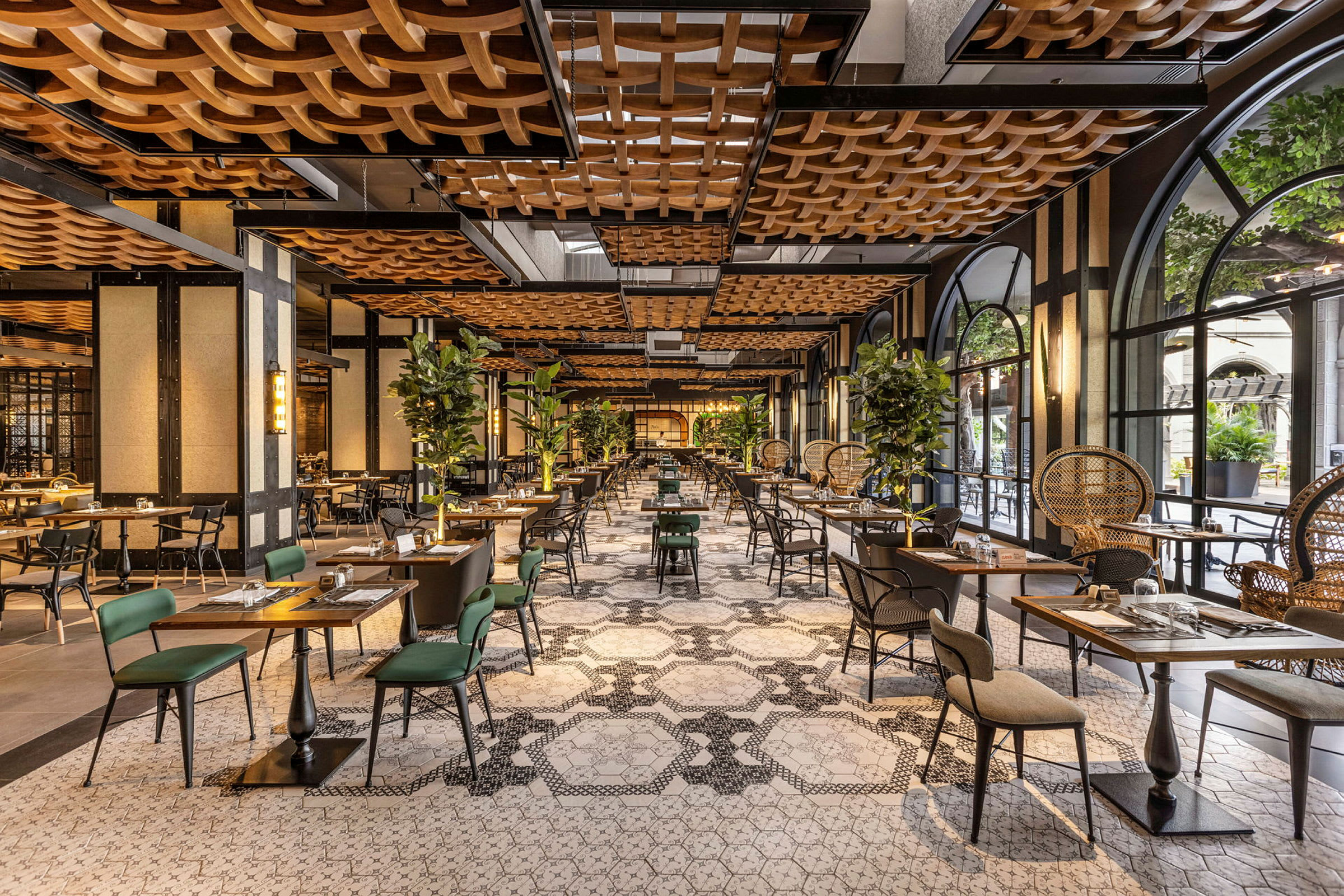 En inbjudande restaurang med elegant inredning, bord och stolar, samt gröna växter som dekoration. (AI-genererad text)