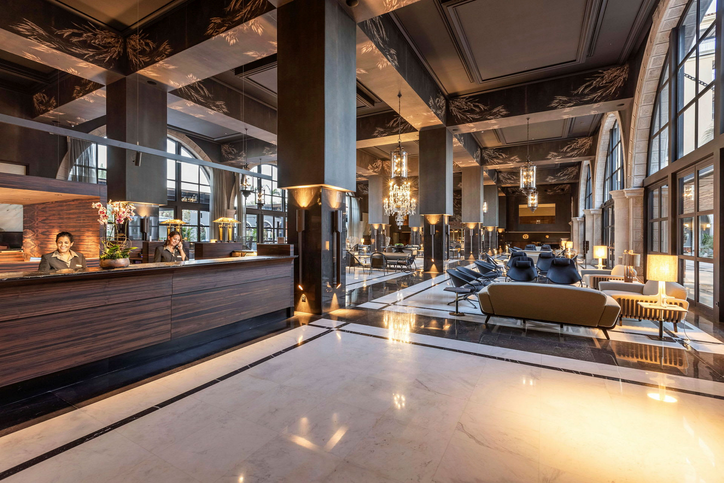 Ett hotellobbyområde med elegant inredning, inklusive soffor och en receptionsdisk. (AI-genererad text)