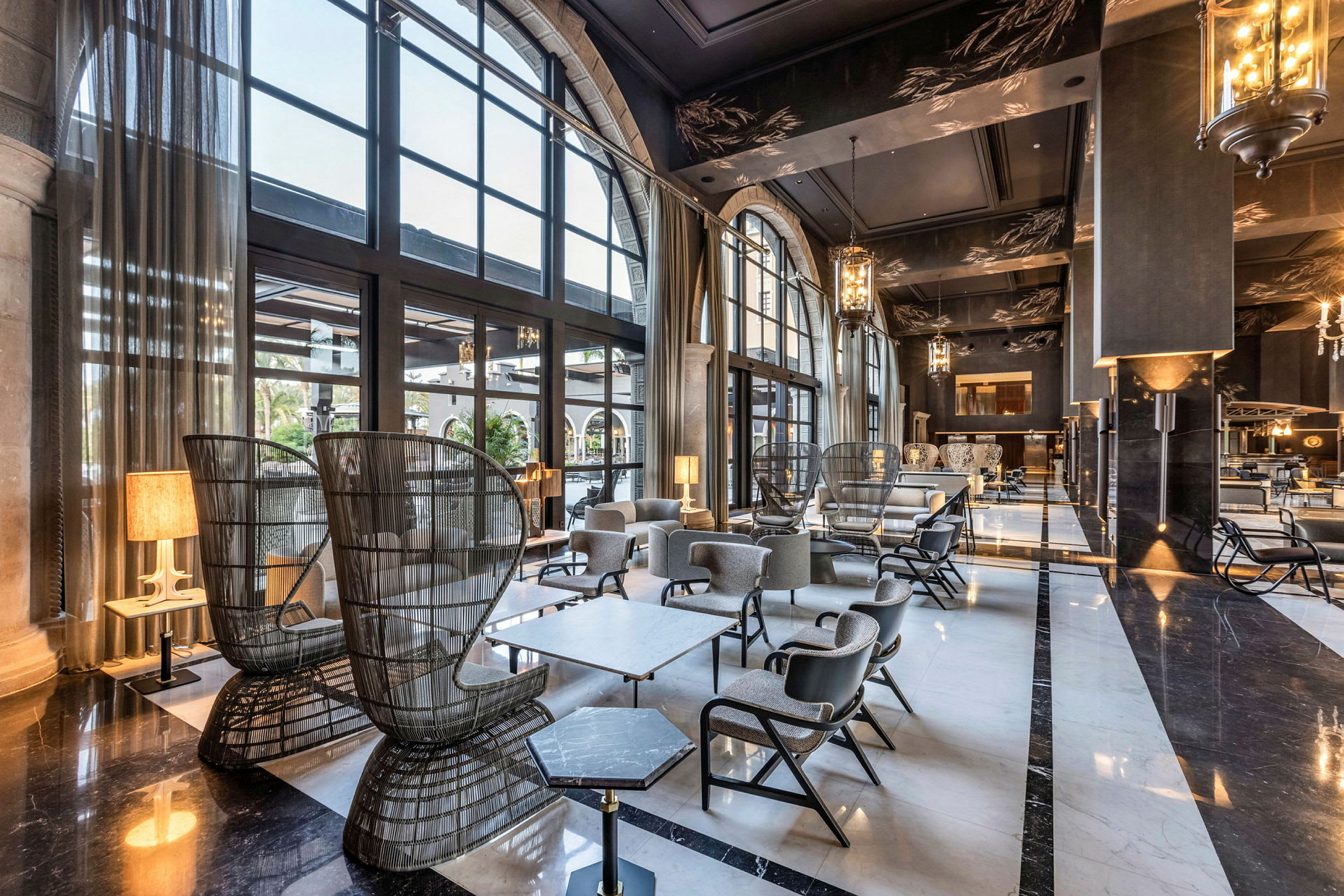 En elegant hotellobby med stora fönster, bekväma sittplatser och modern inredning. (AI-genererad text)