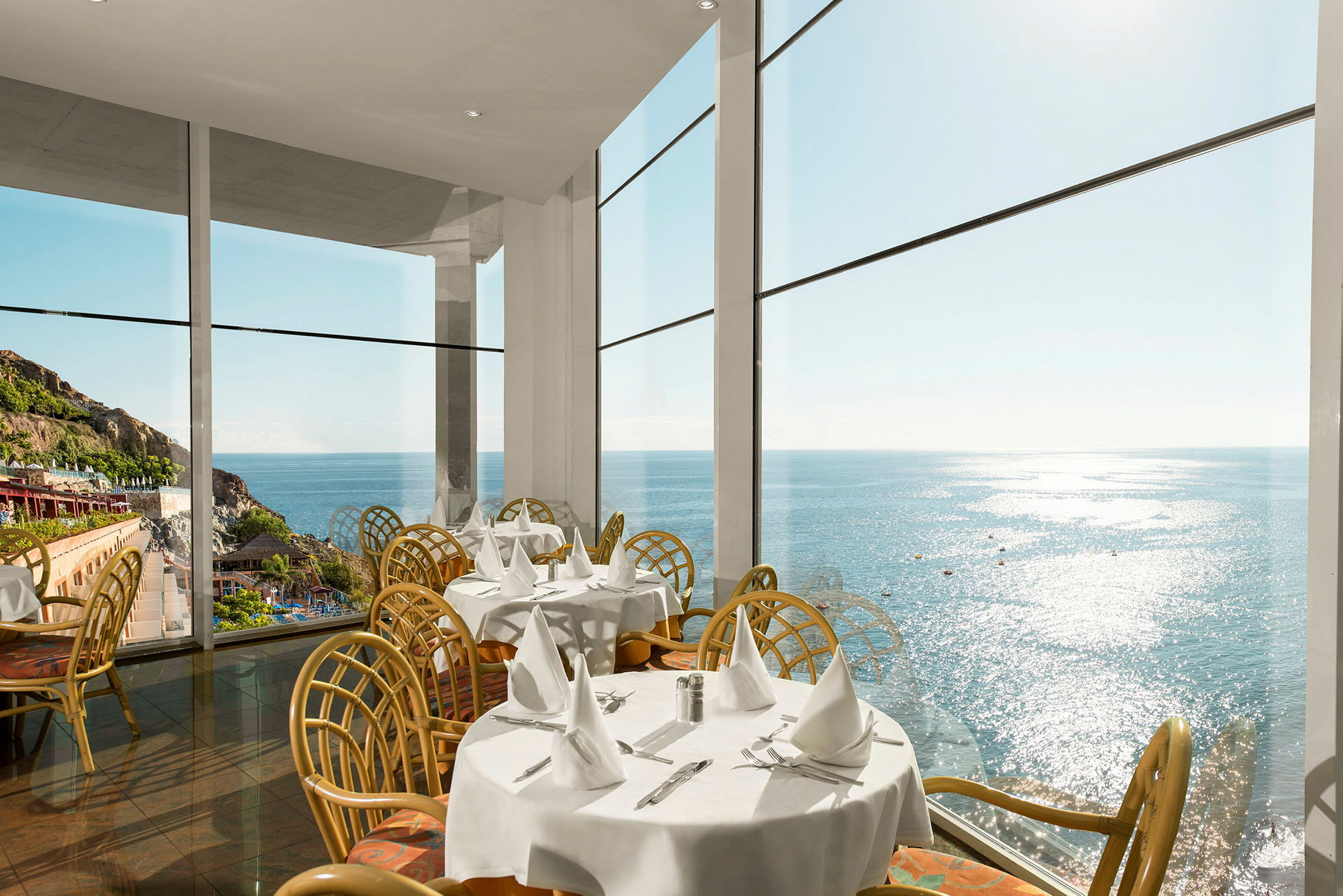 Restaurang med stora fönster och utsikt mot havet. (AI-genererad text)