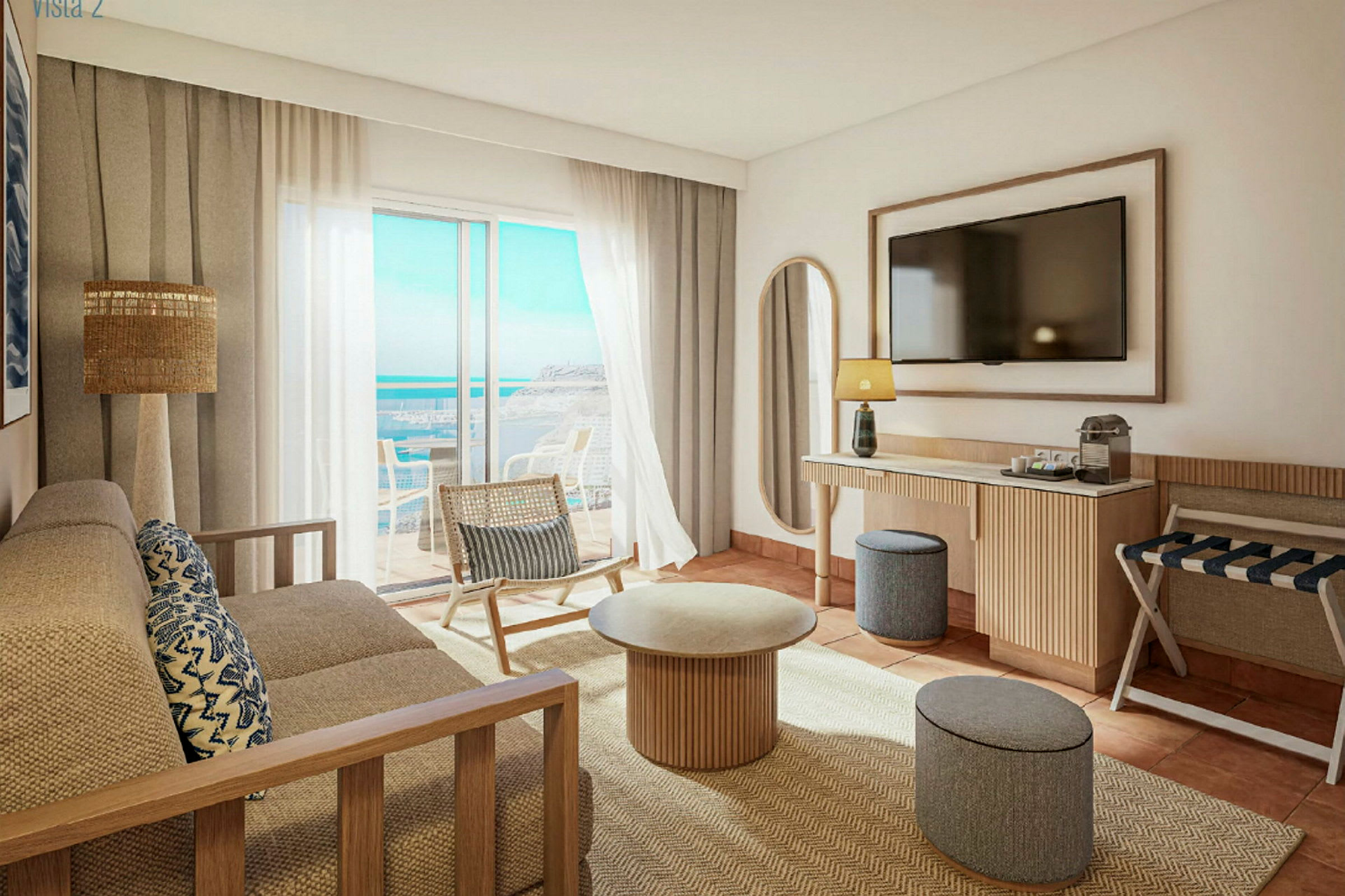Ett ljust och modernt hotellrum med utsikt över havet. Det finns en soffa, ett soffbord, en stol och en TV på väggen. (AI-genererad text)