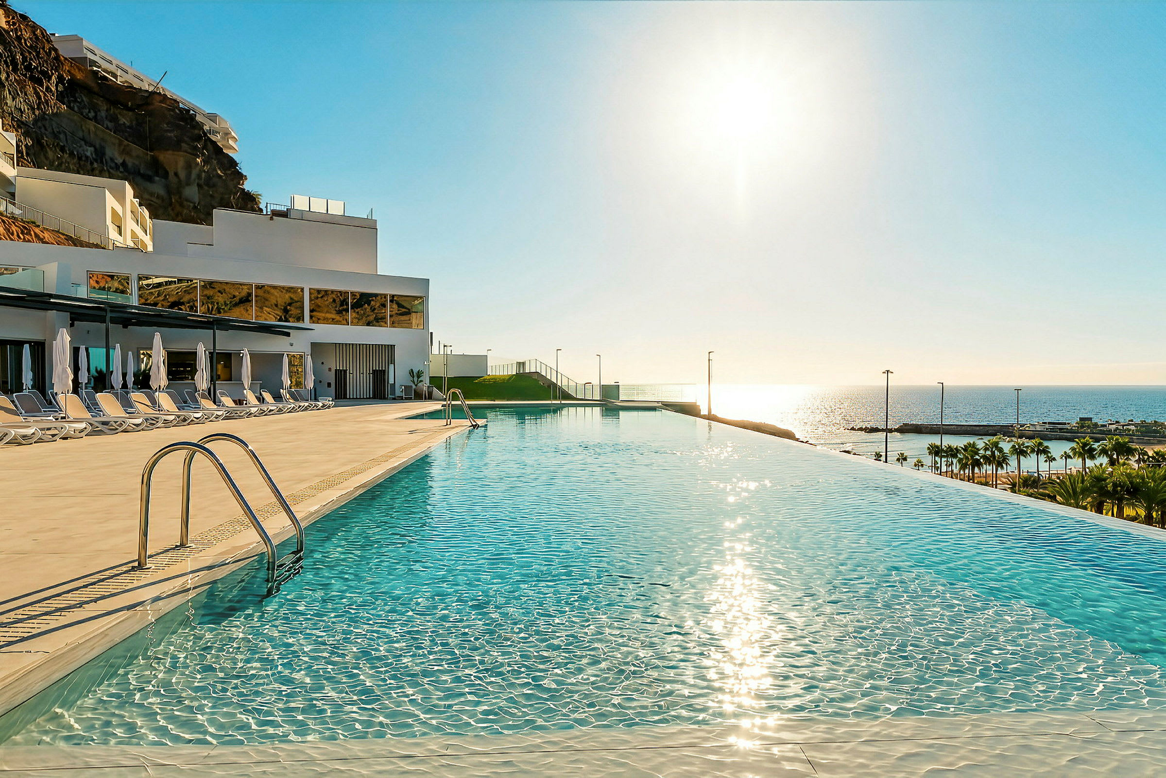 En infinity-pool med utsikt över havet och en solig himmel. (AI-genererad text)