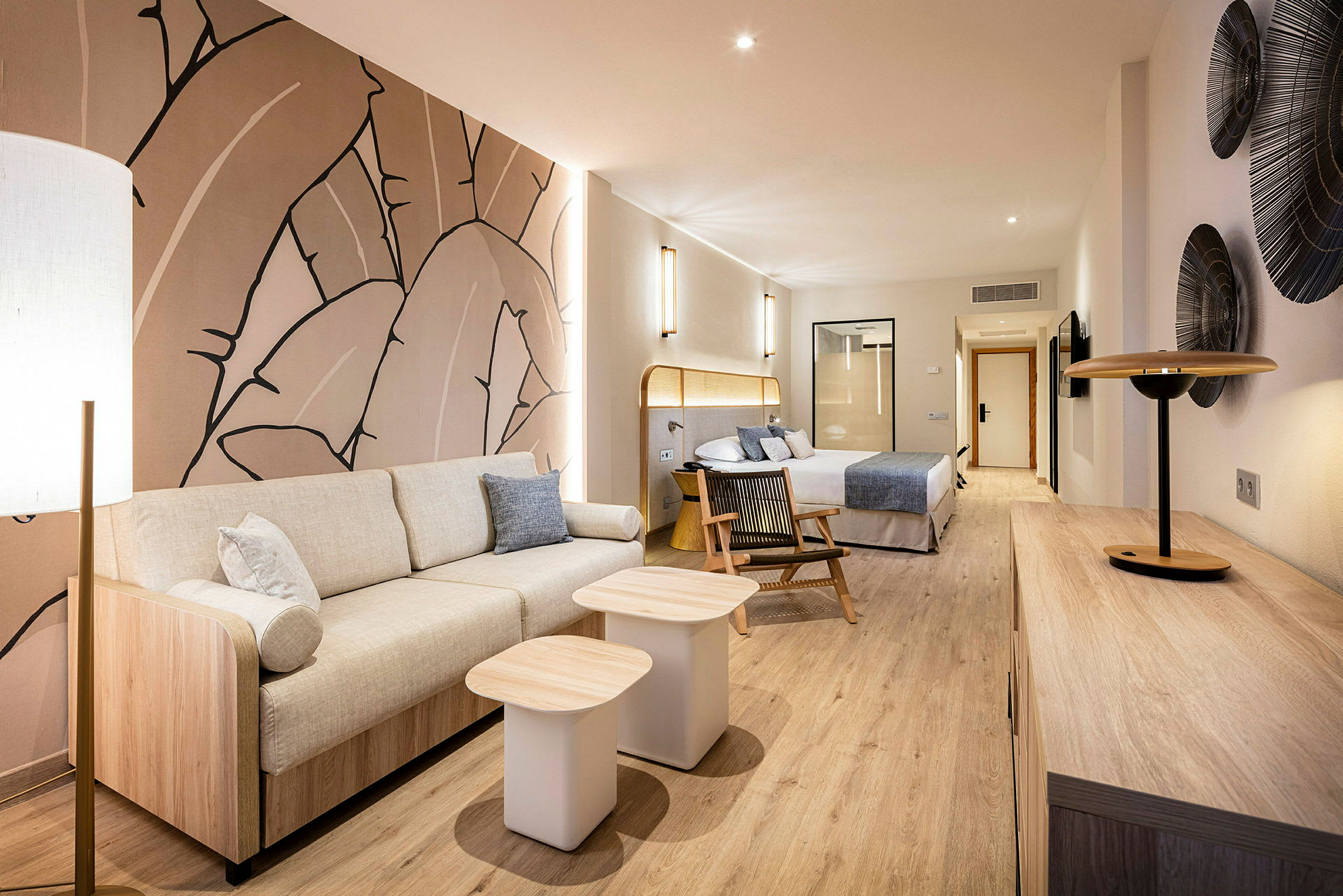 Modern hotellsvit med sittgrupp, säng och dekorativ konst på väggen. (AI-genererad text)