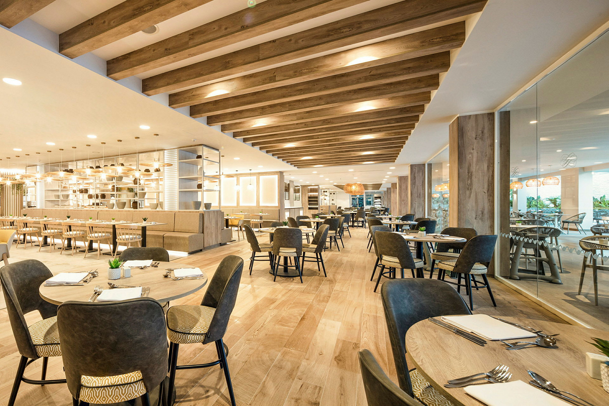 Interiör av en modern restaurang med bord och stolar, trädetaljer och ljussättning. (AI-genererad text)