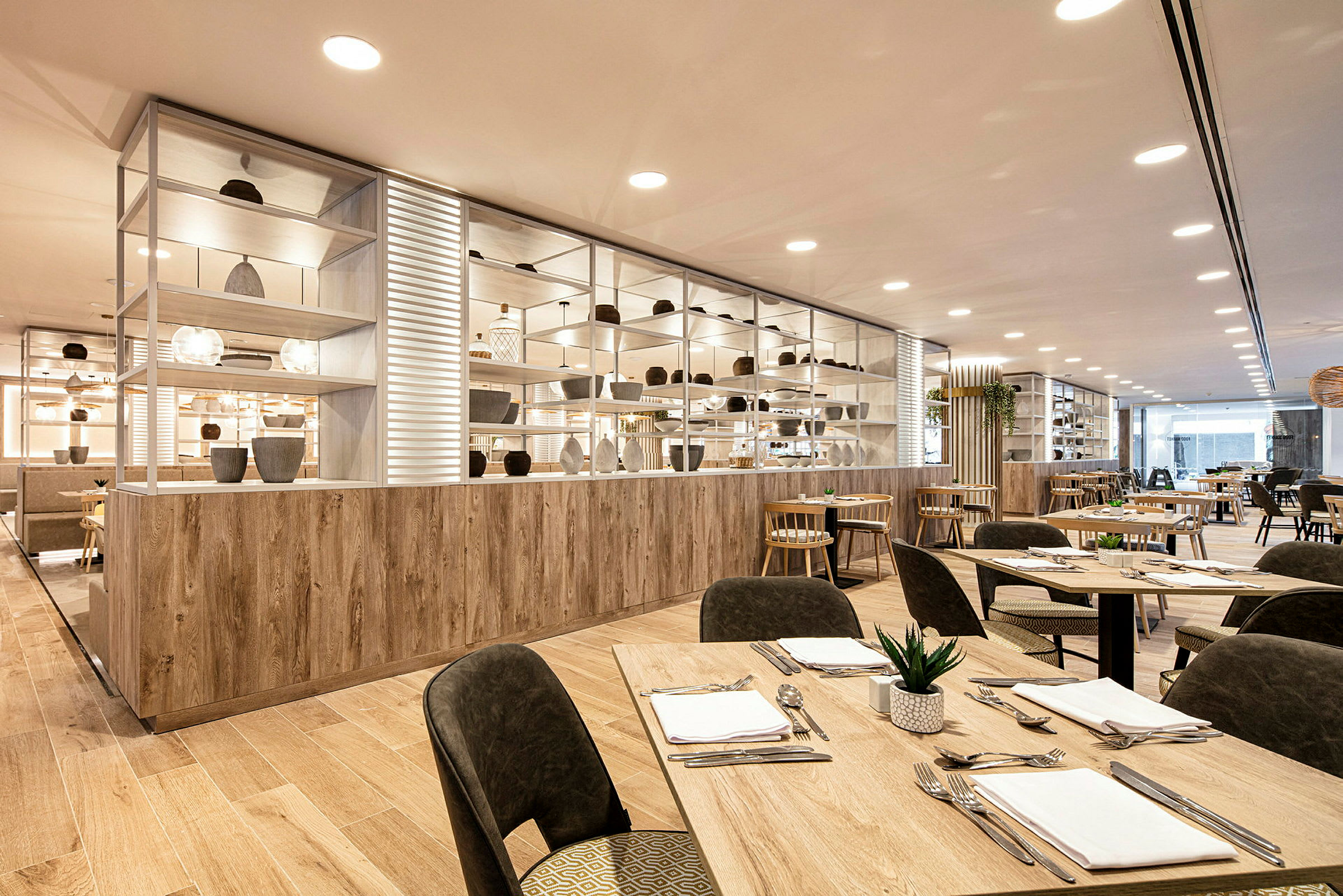 Bild av en modern restaurang med träbord och stolar samt dekorativa hyllor. (AI-genererad text)