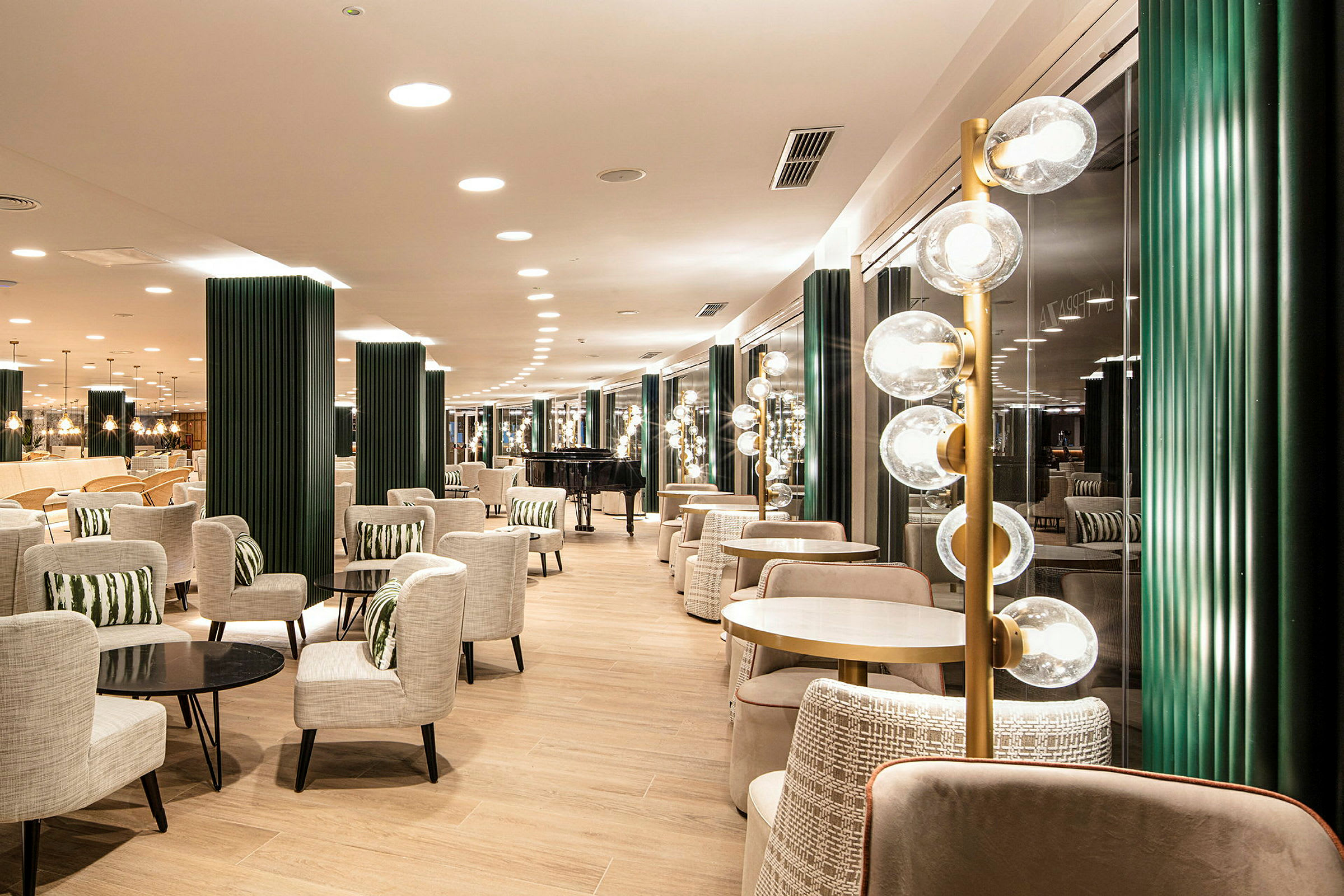 En modern loungemiljö med bord, stolar och dekorativa ljusarmaturer. (AI-genererad text)