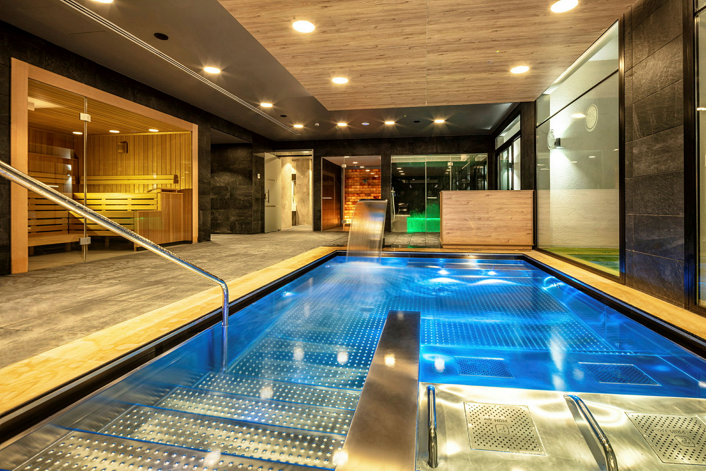 Interiör av ett spa med en pool och bastu. (AI-genererad text)
