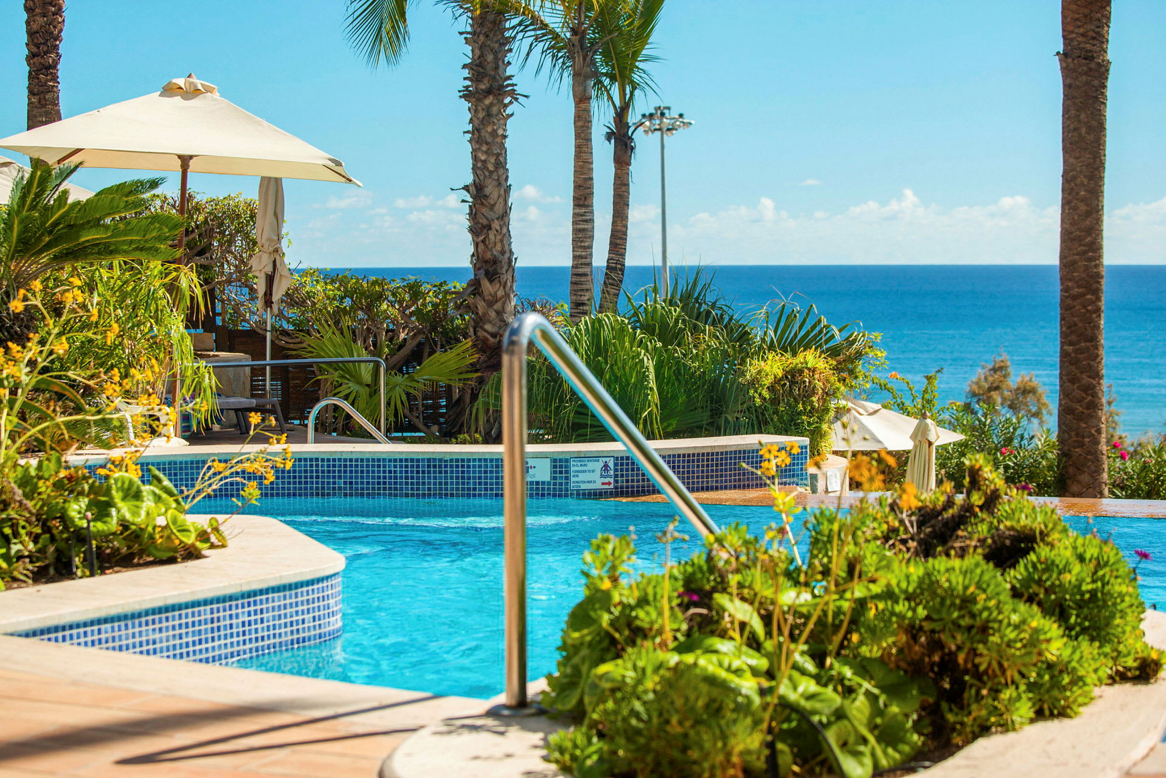 Swimmingpool vid exotisk resort med havsutsikt. (AI-genererad text)