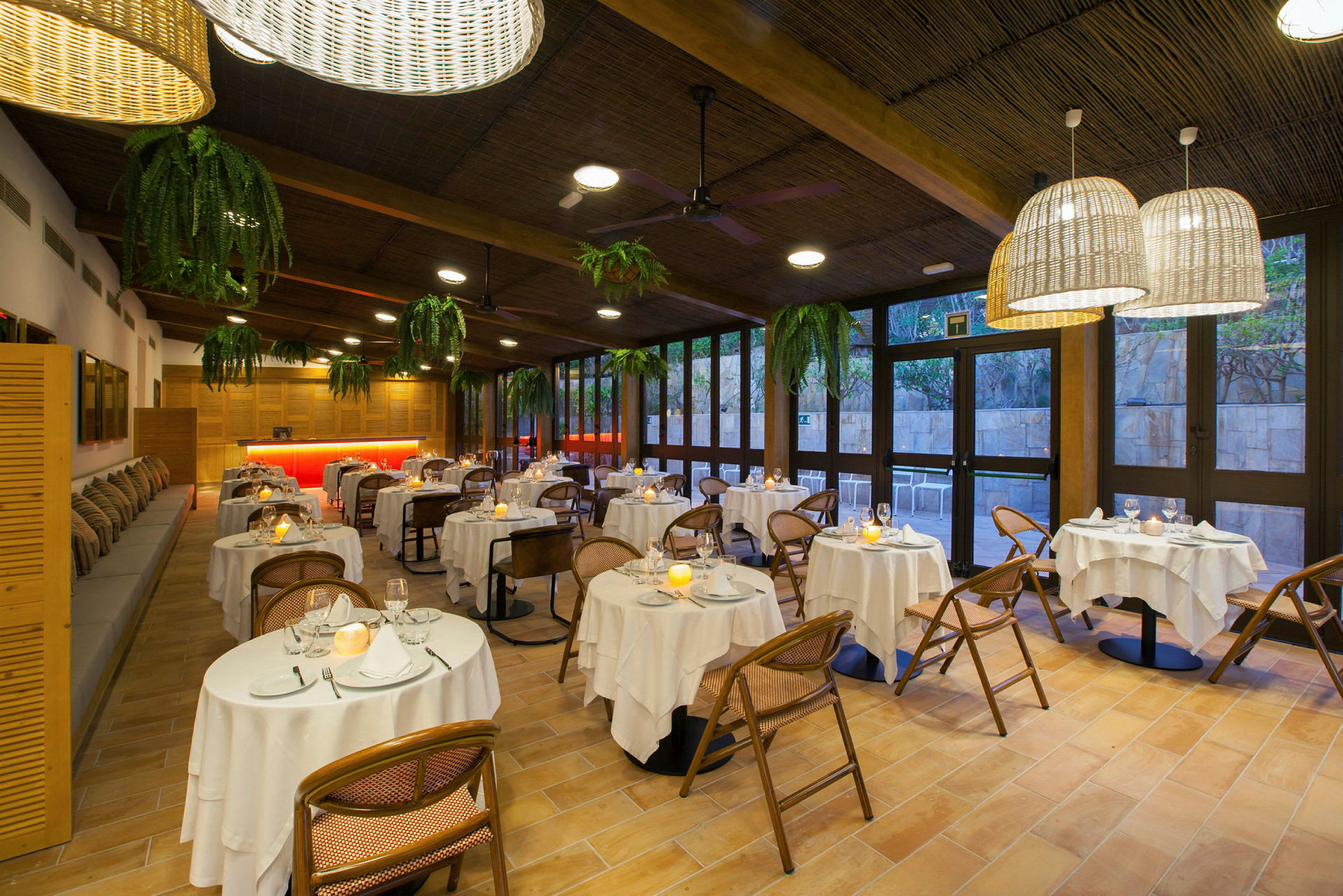 En restaurang med runda bord, vita dukar och stolar. (AI-genererad text)