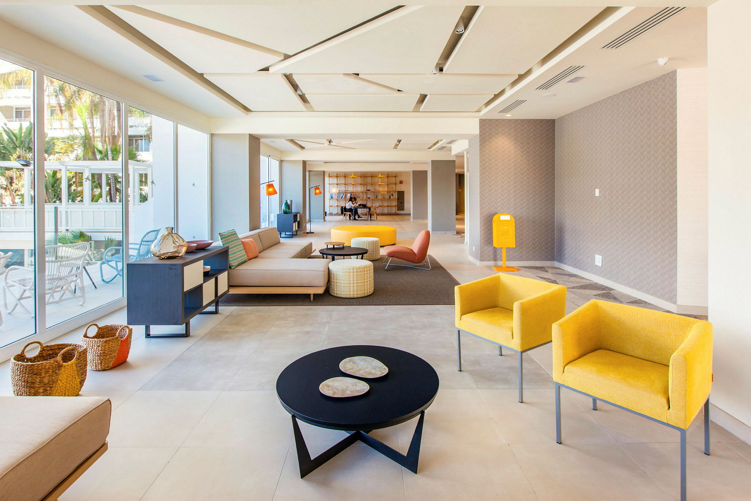 Ljus och modern hotellobby med sittgrupper och glasväggar. (AI-genererad text)