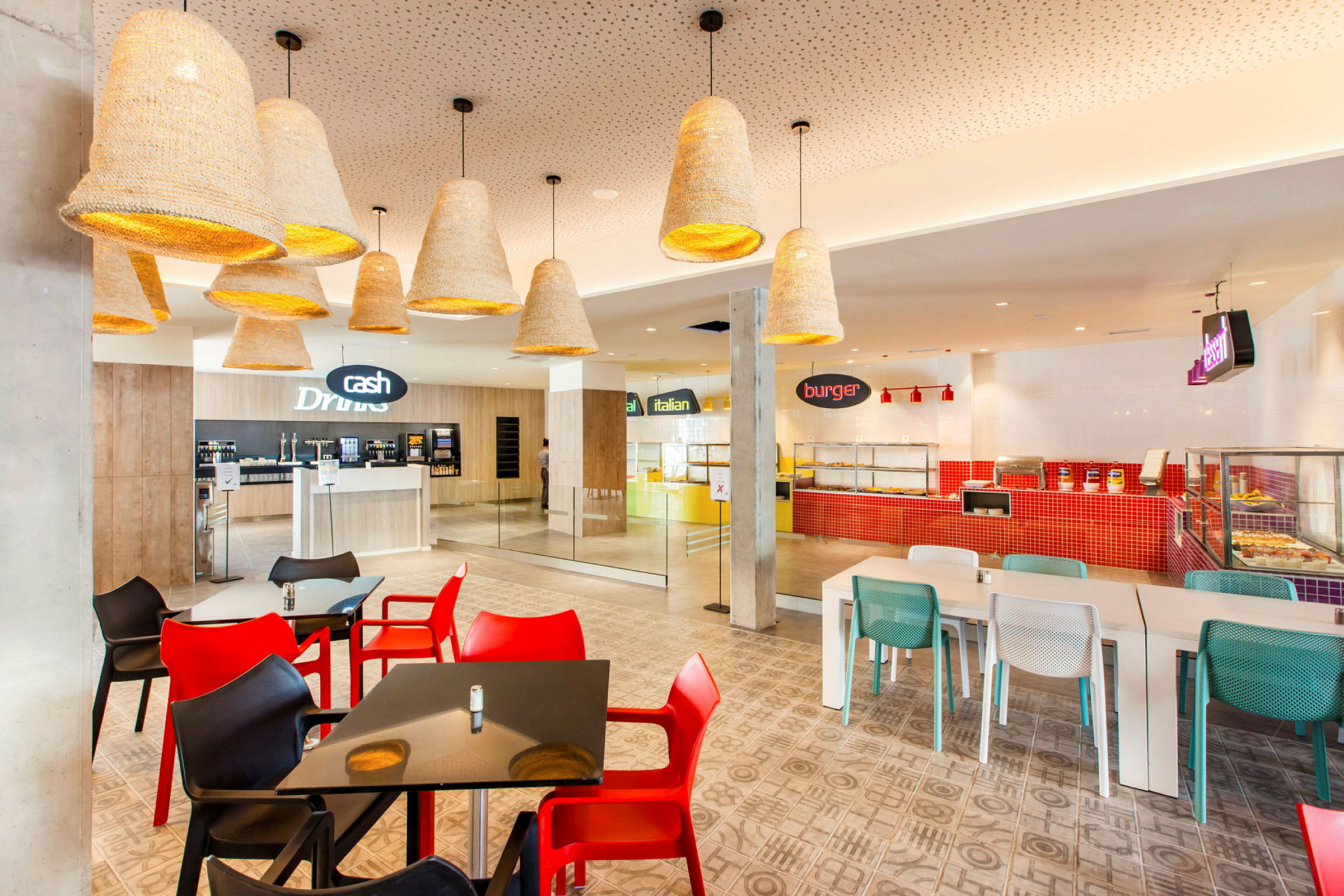 Bild av en modern restaurang med färgglada stolar och olika matstationer. (AI-genererad text)